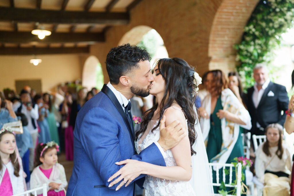Wedding celebration in a rustic venue with brick walls and wooden beams overhead.