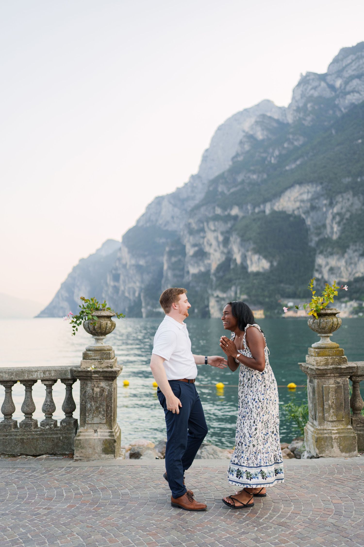 Engaged couple embracing beside Lake Garda during their Riva del Garda proposal session