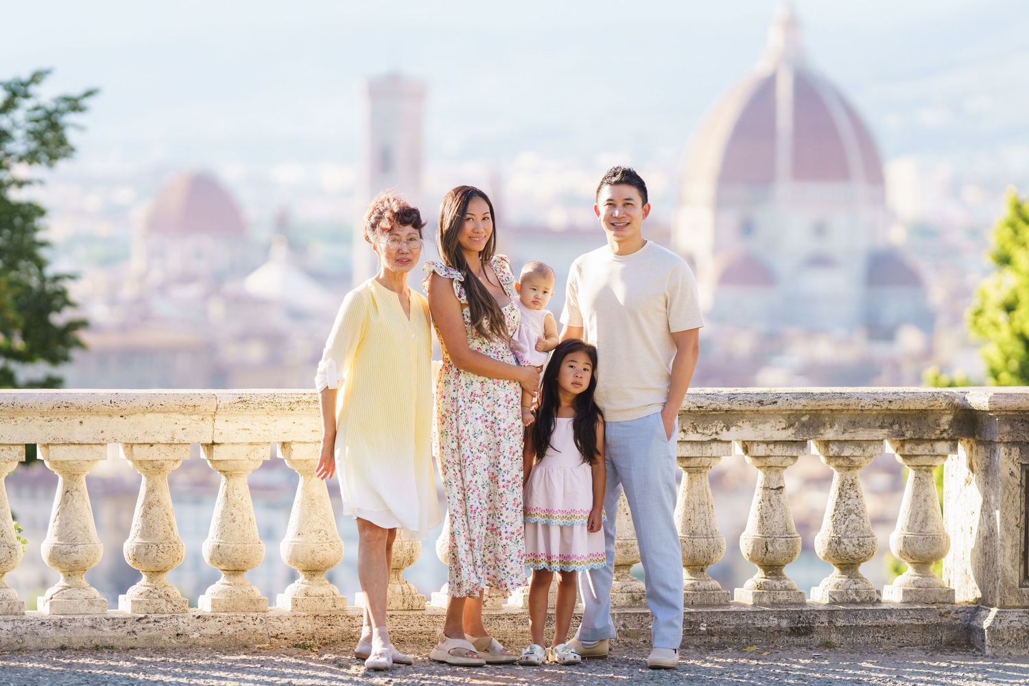 Family of five posing on a terrace in Florence, Italy, with the iconic Duomo cathedral visible in the background.