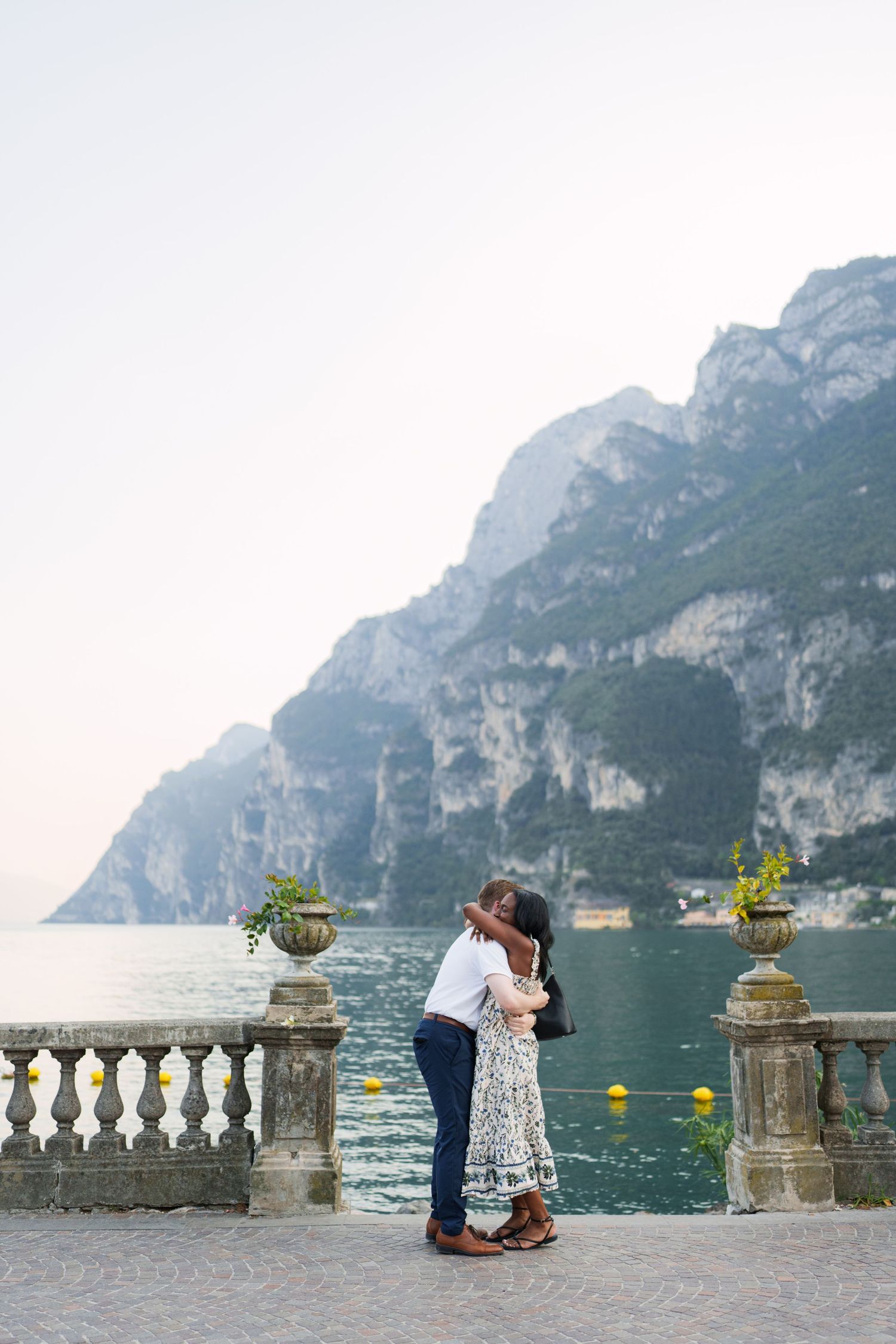 Couple walking together along the waterfront after their proposal in Riva del Garda