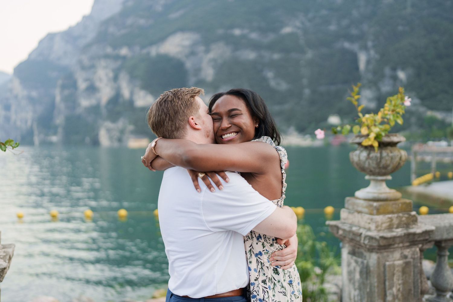 Engaged couple embracing beside Lake Garda during their Riva del Garda proposal session
