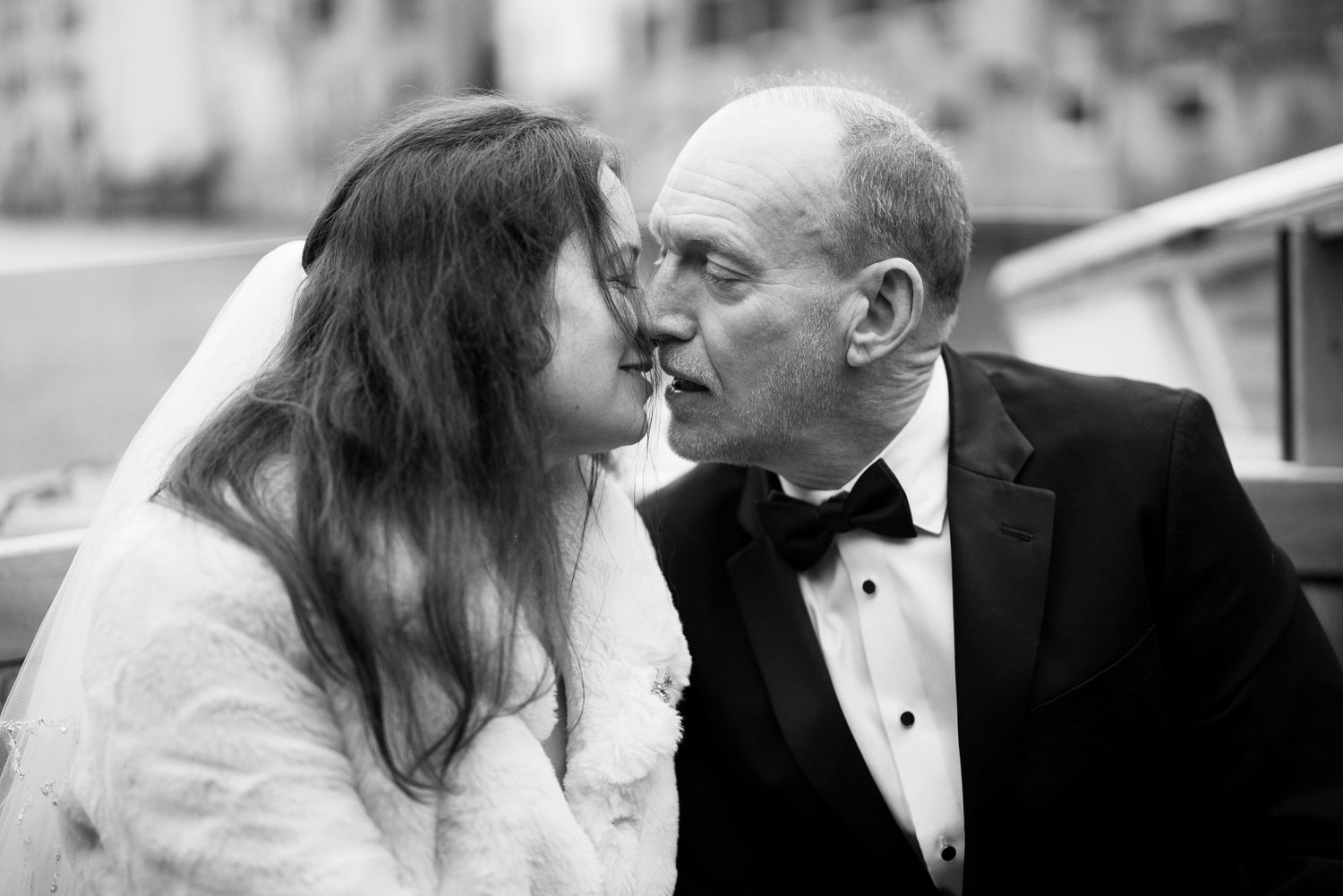 Black and white wedding photo collage showing romantic moments between newlyweds in formal attire.