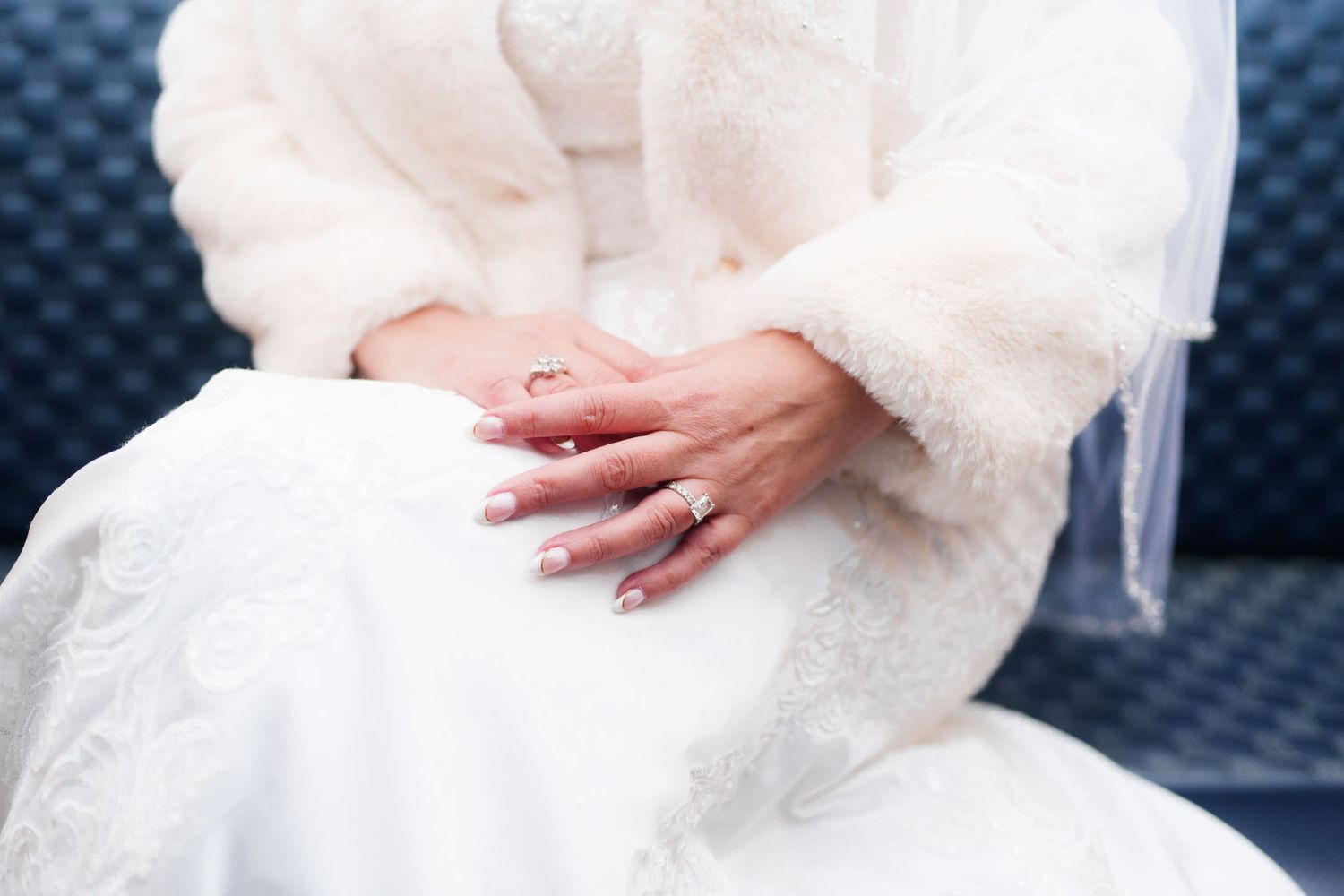 Close-up shots of hands gently holding delicate white lace fabric against a dark blue textured background.