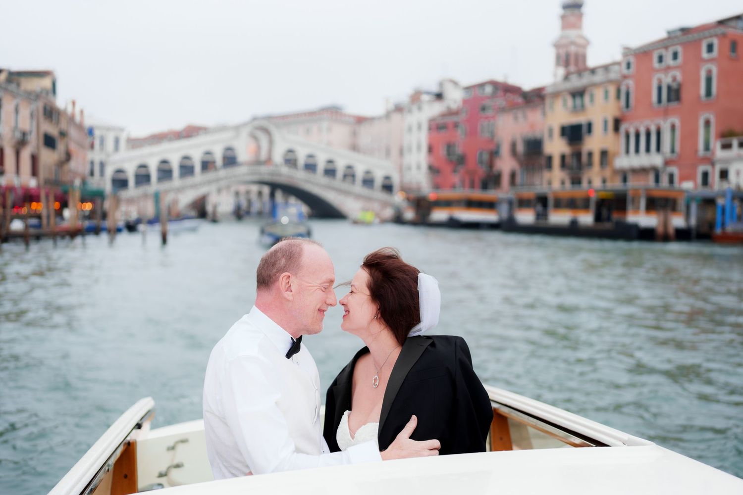 A romantic couple shares intimate moments while riding in a gondola along the scenic canals of Venice, Italy.