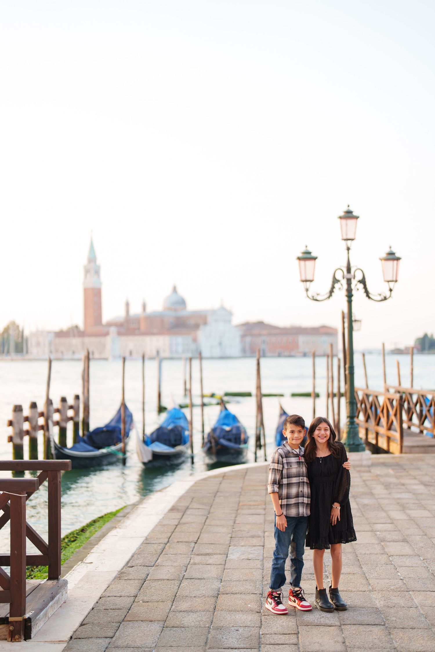 Romantic couples stand along the Venice waterfront with gondolas and the iconic cityscape visible in the background.