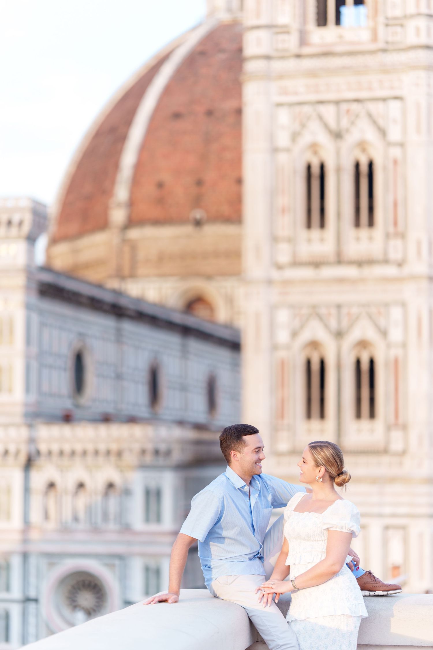 Couple enjoys romantic moment in front of Florence Cathedral's iconic dome and architecture in Italy.