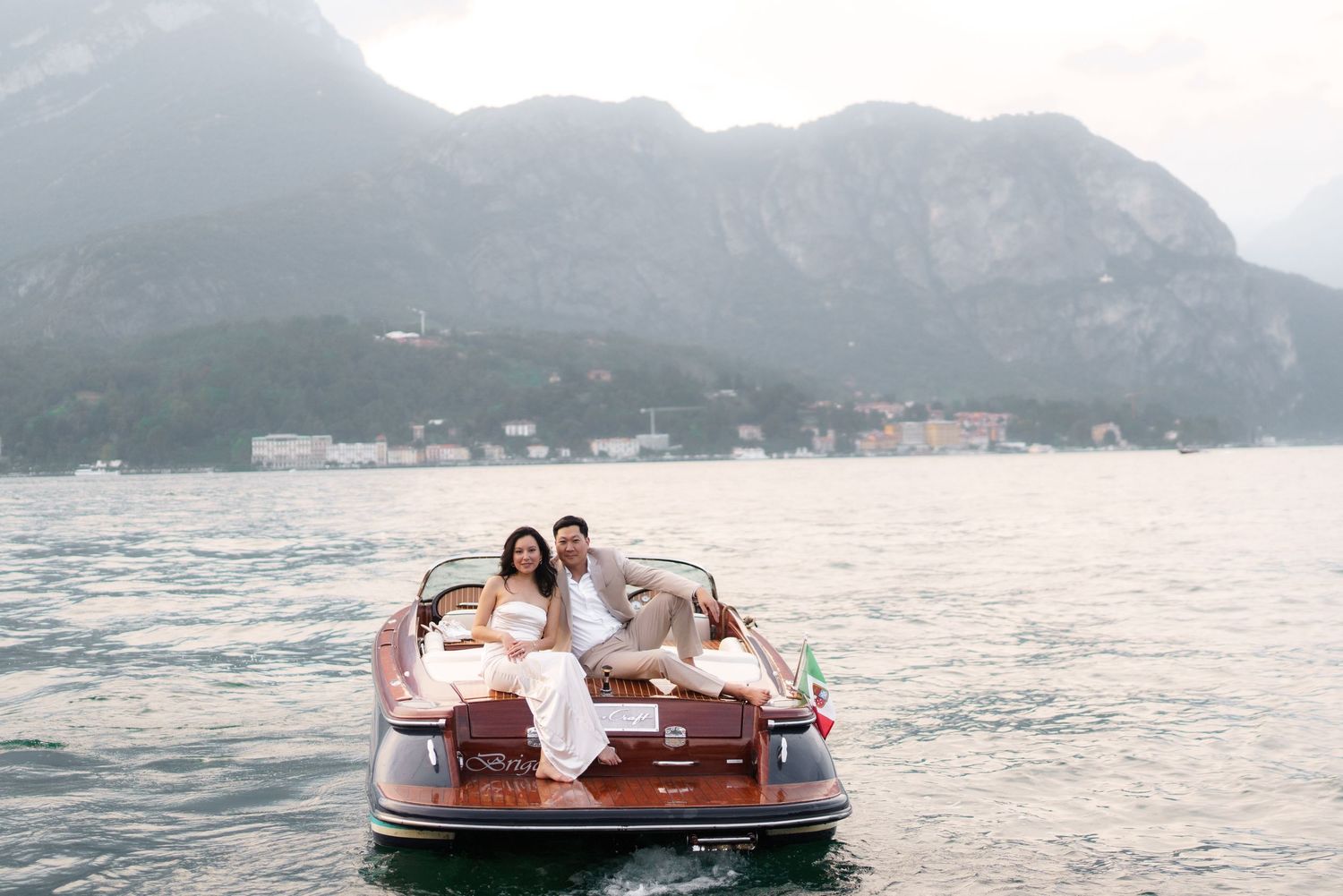 A group enjoys a scenic boat ride across tranquil waters with mountains in the background.