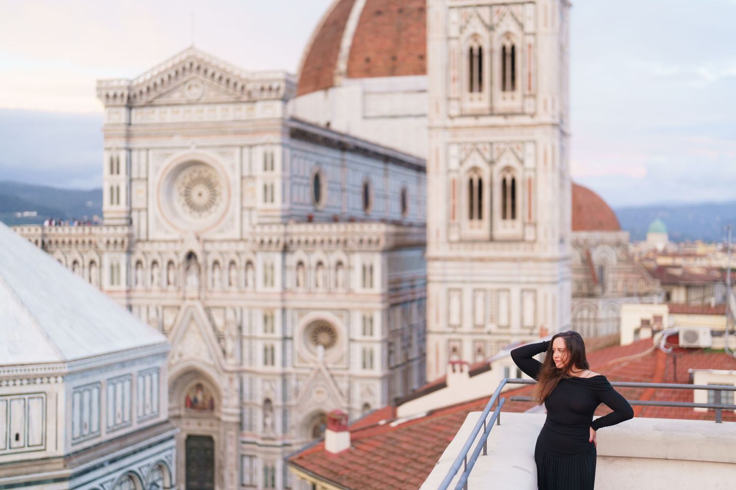 Tourists take photos in front of the iconic Florence Cathedral and Duomo with its distinctive Renaissance architecture.