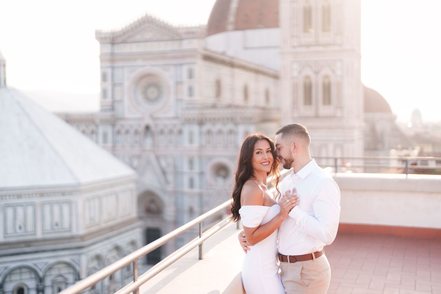 Romantic couple embraces during sunset photoshoot at Florence Cathedral in Italy.