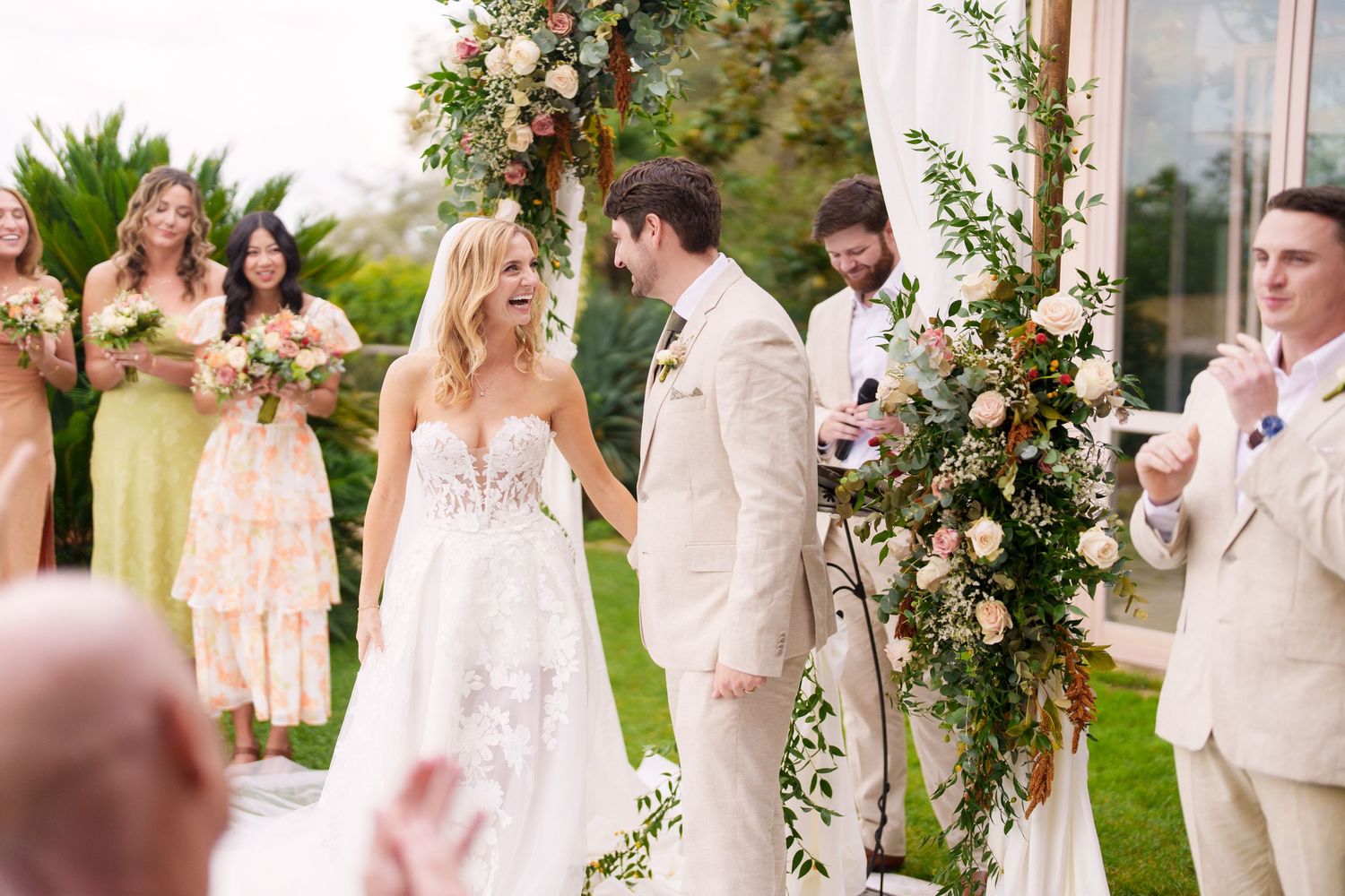 Romantic outdoor wedding ceremony with floral decorations and cream-colored attire.