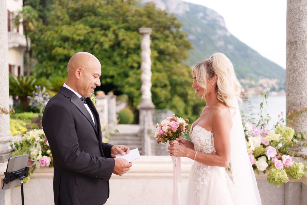 Romantic wedding moment on an elegant Italian villa terrace overlooking the lake.