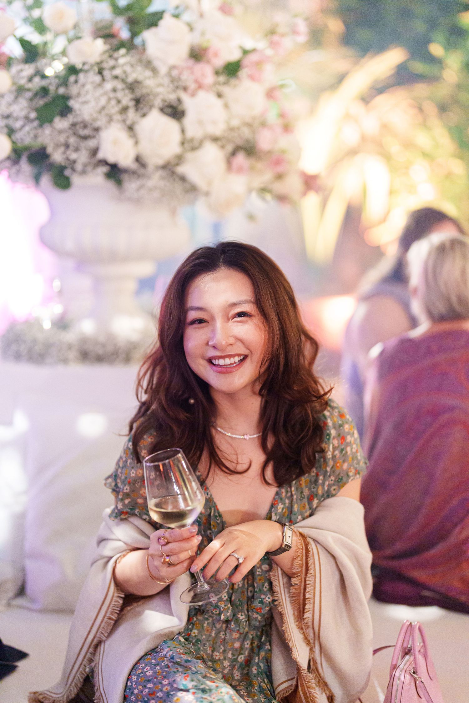 Guest enjoying wine and conversation at an elegant reception with floral decorations.