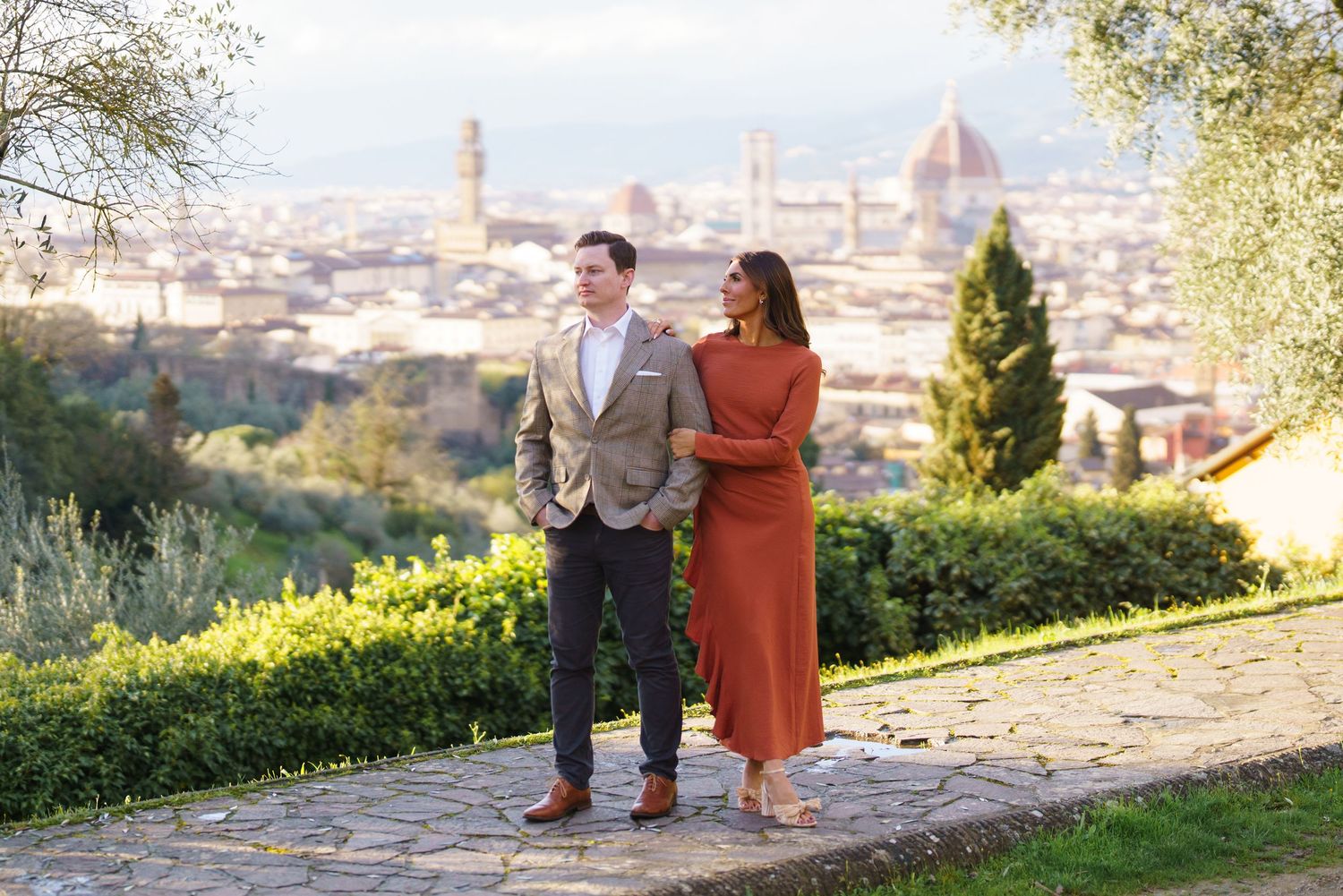 Couple posing in Florence Italy with panoramic cityscape featuring the Duomo cathedral in the background.