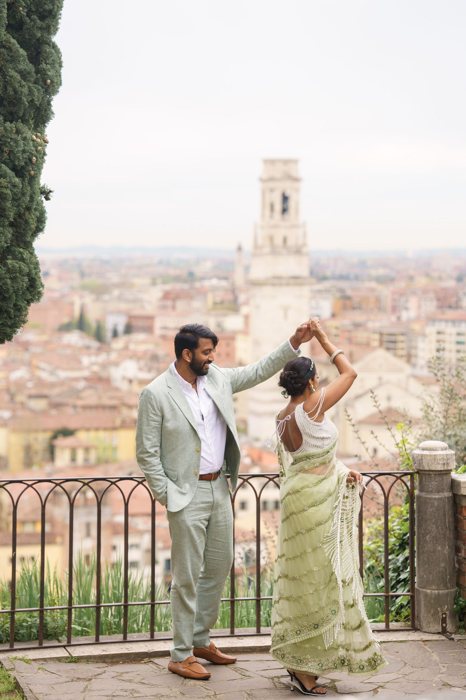 A couple in formal attire poses for romantic photos on a scenic overlook terrace above Florence, Italy.