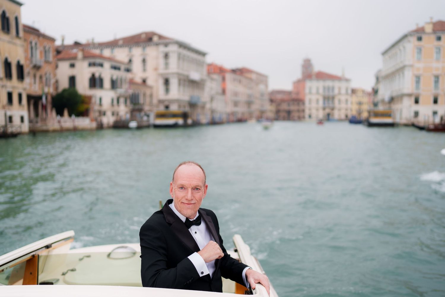 A scenic view of Venice's historic canals and buildings with boats passing through the turquoise waters.