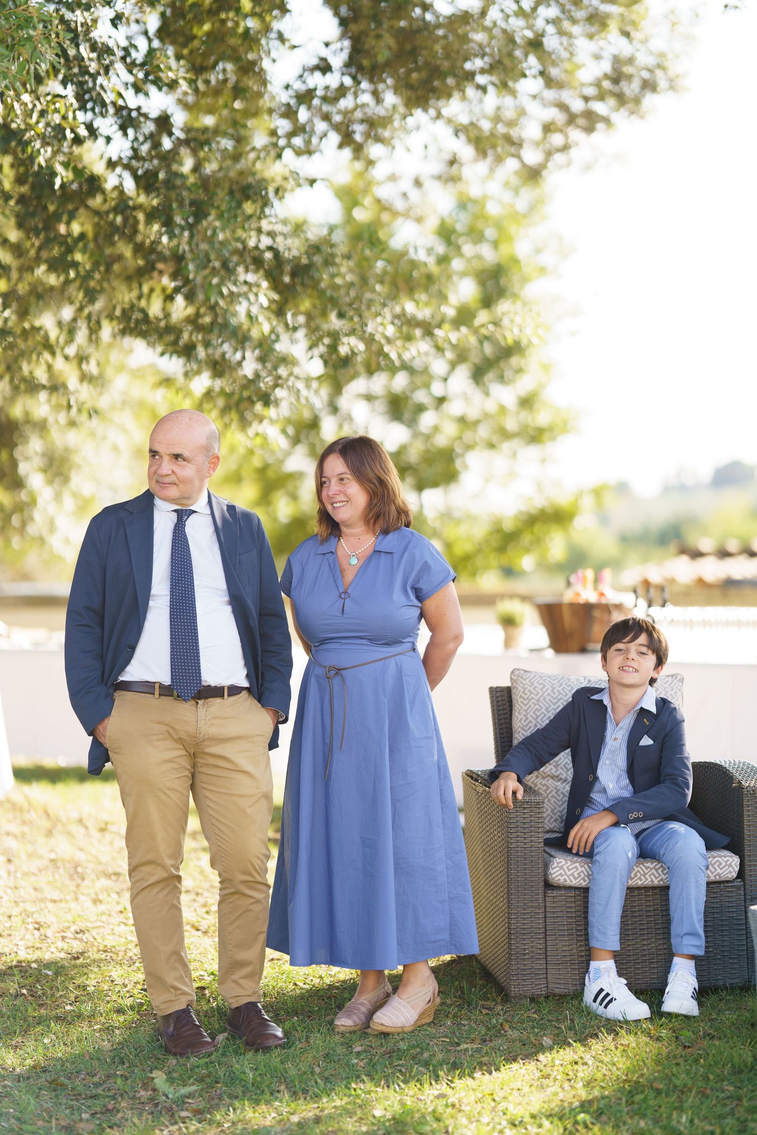 Family members sitting casually on outdoor furniture wearing coordinated blue and khaki outfits.