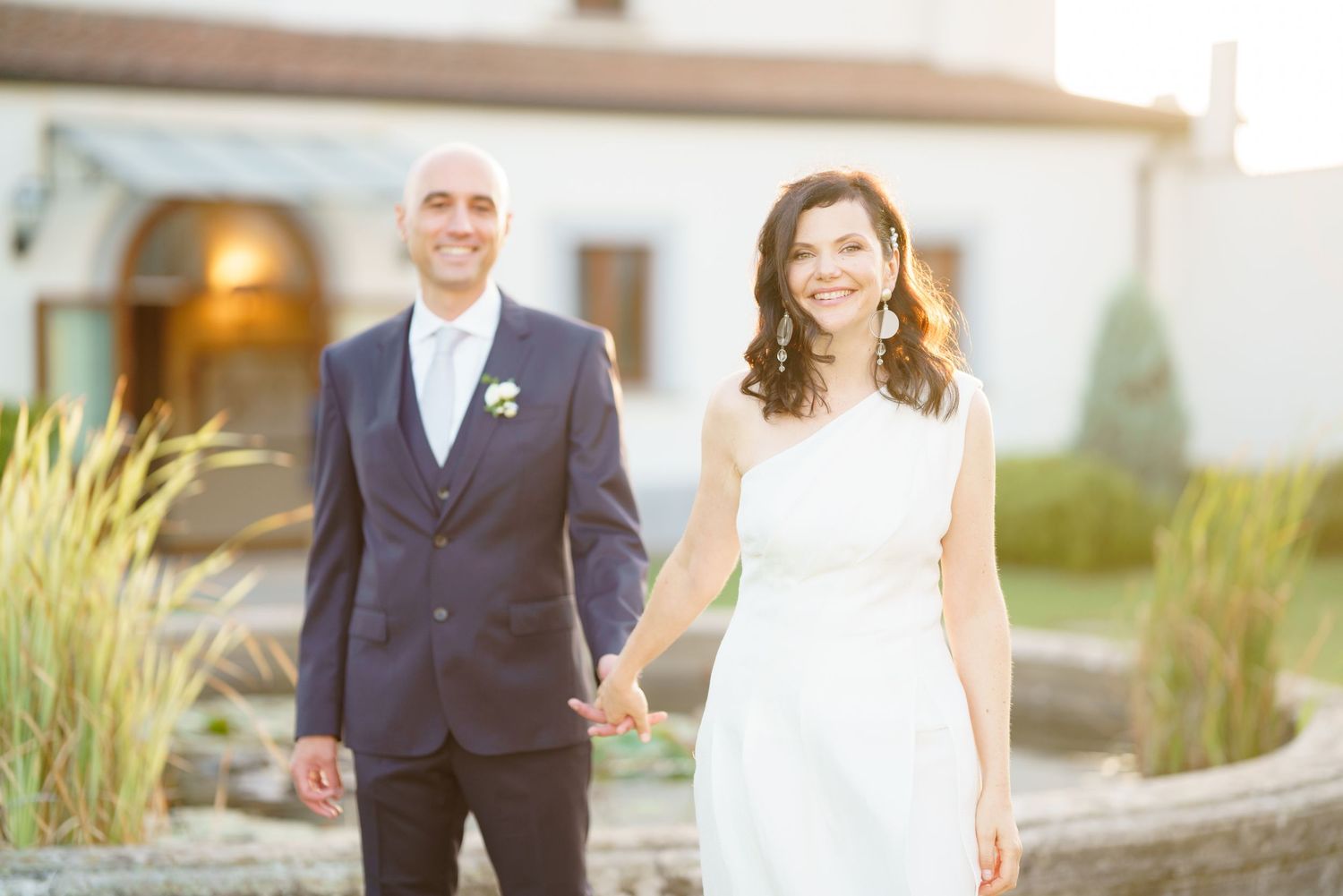 Wedding party members in formal attire standing together outside venue.