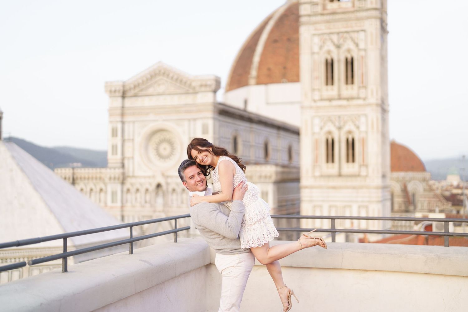 Couple poses romantically in front of Florence Cathedral during sunset in Italy, capturing iconic Duomo architecture.