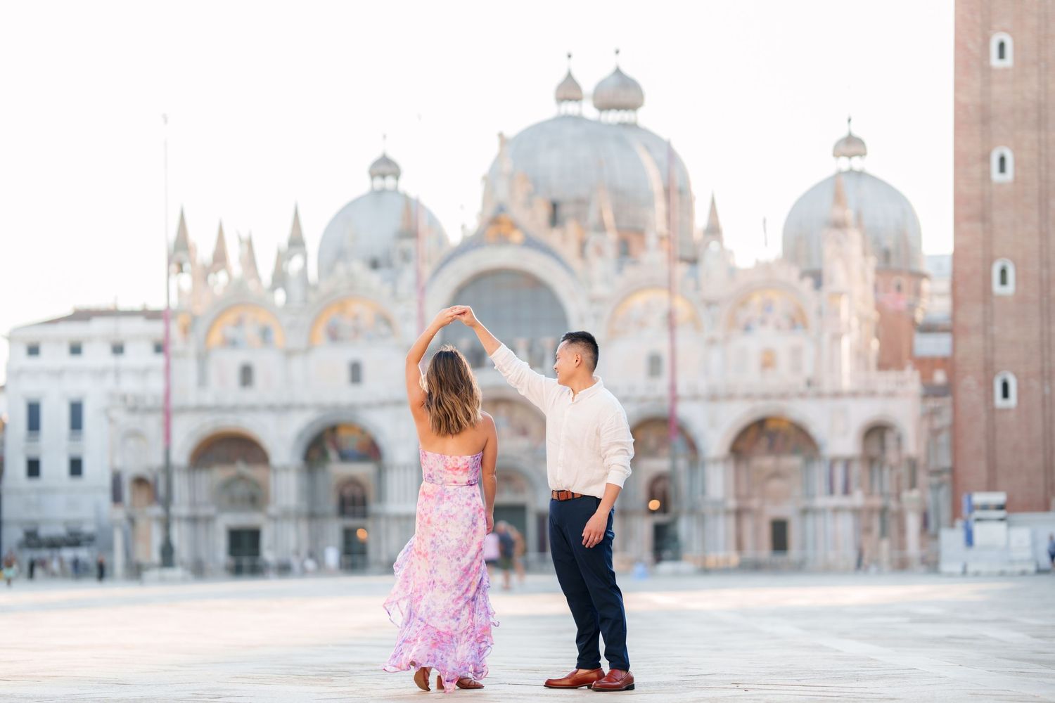 Couple dancing in St. Mark's Square, Venice, with the iconic Basilica di San Marco in the background.