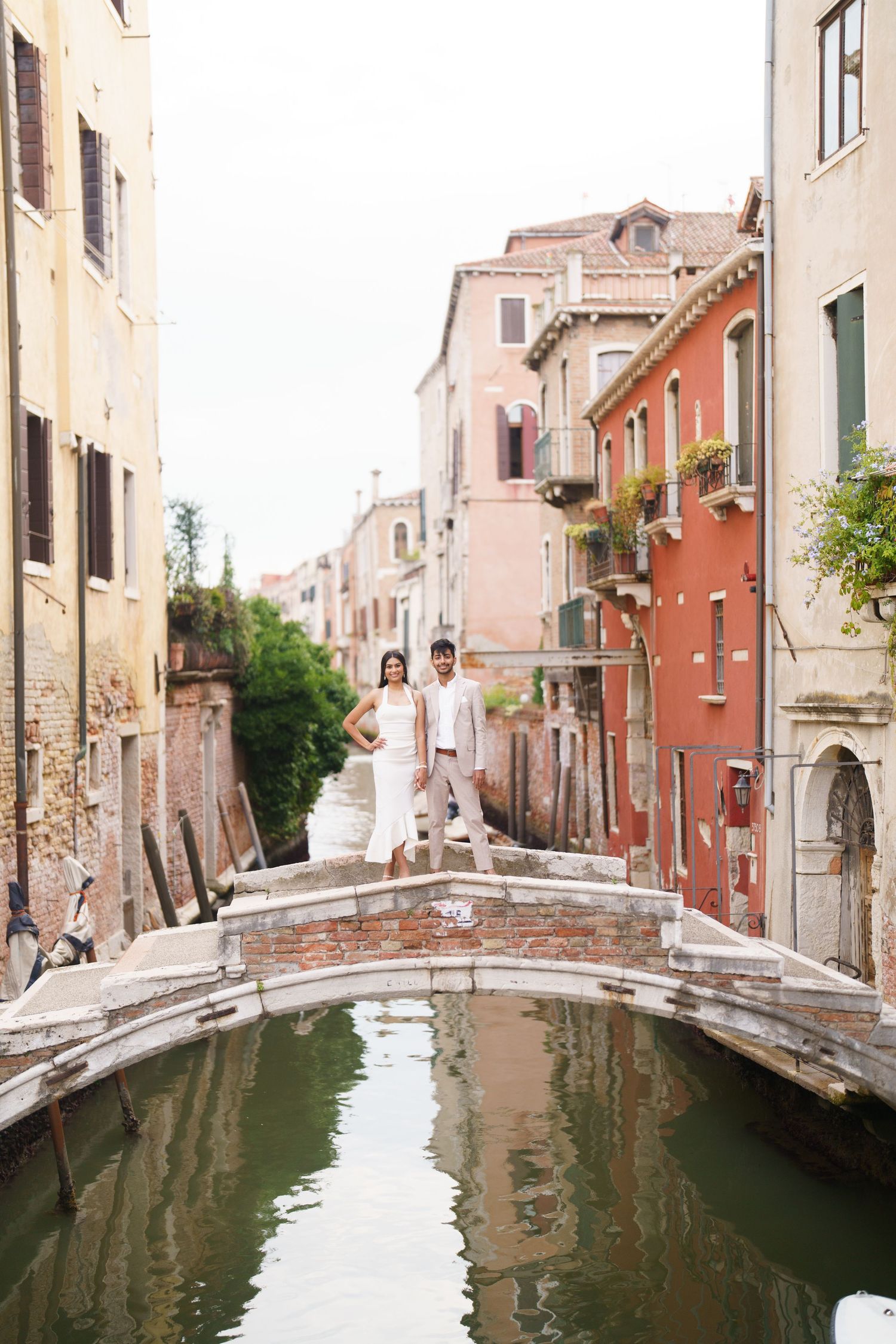 Scenic view of Venice canals with colorful buildings and small bridges reflecting in the calm water.