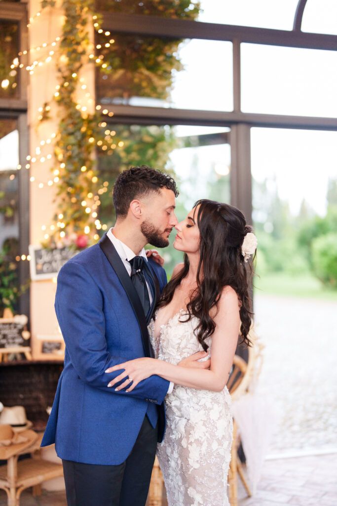 Romantic indoor wedding venue with string lights and greenery decorations.