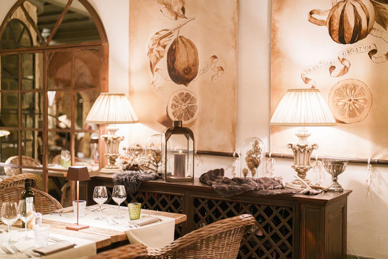 Romantic restaurant interior with arched mirrors, table settings and warm lighting.