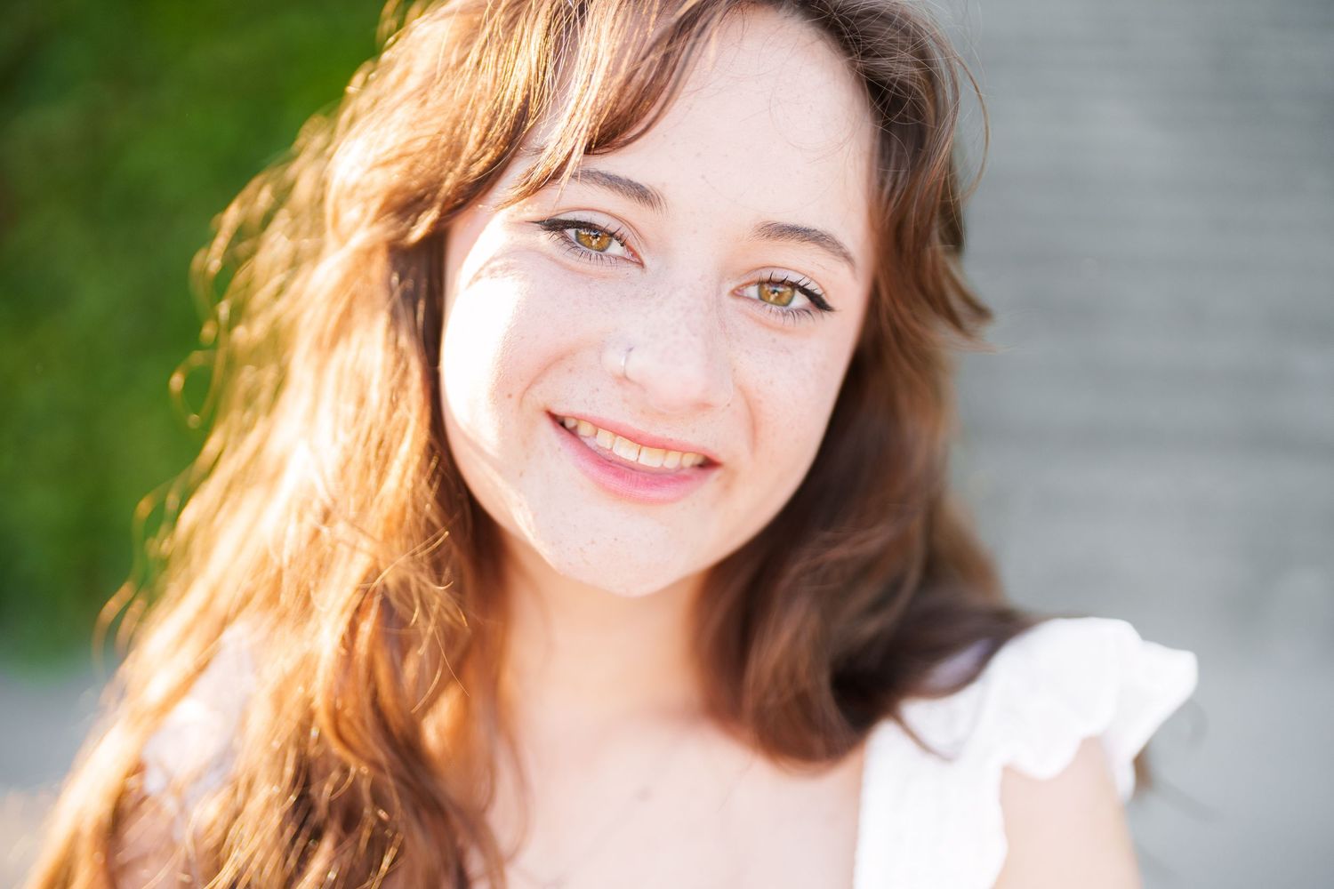 A portrait series showing someone with long brown hair in natural sunlight with varying expressions and poses.