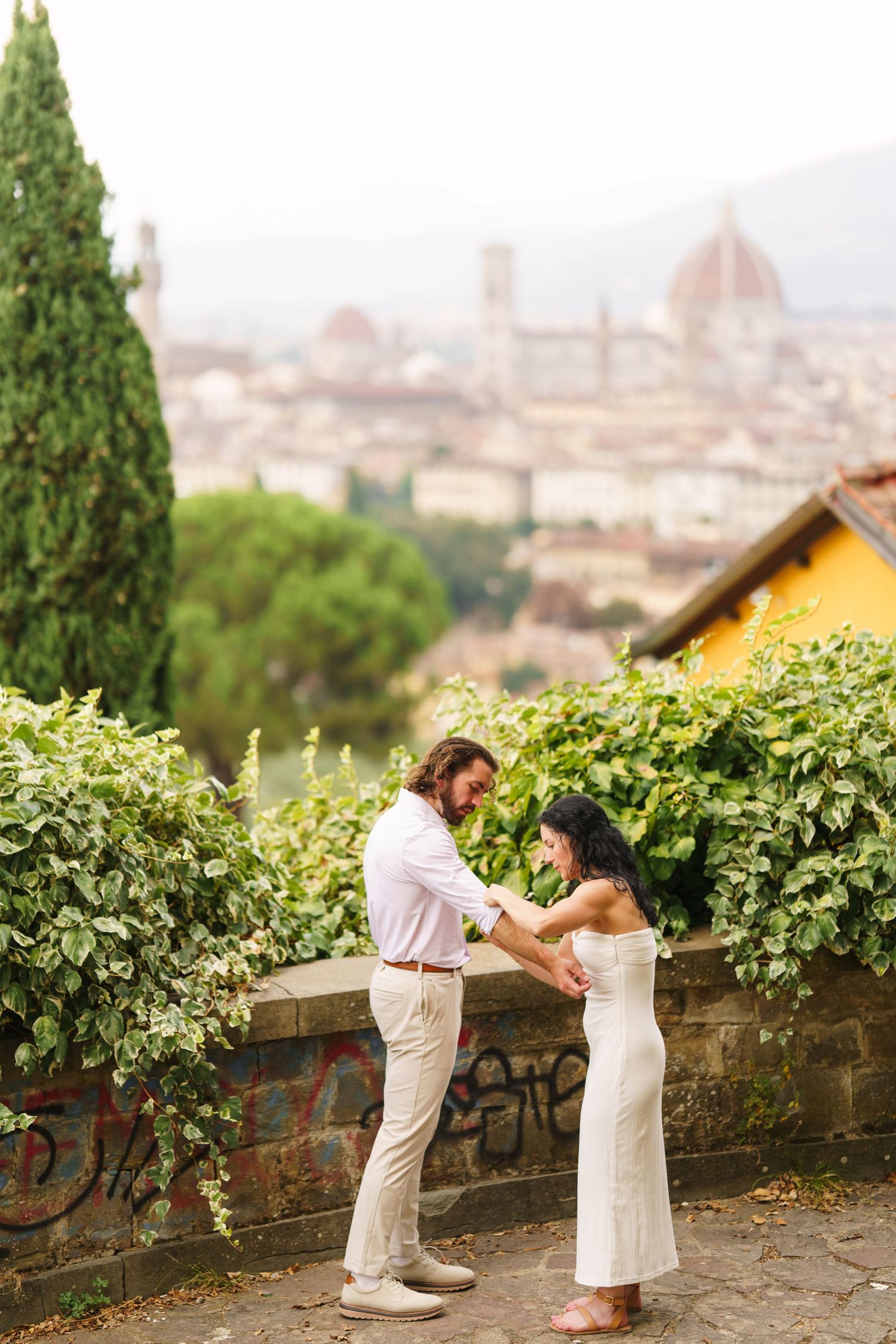 A romantic proposal moment overlooking the scenic skyline of Florence, Italy with the iconic Duomo cathedral visible in the distance.