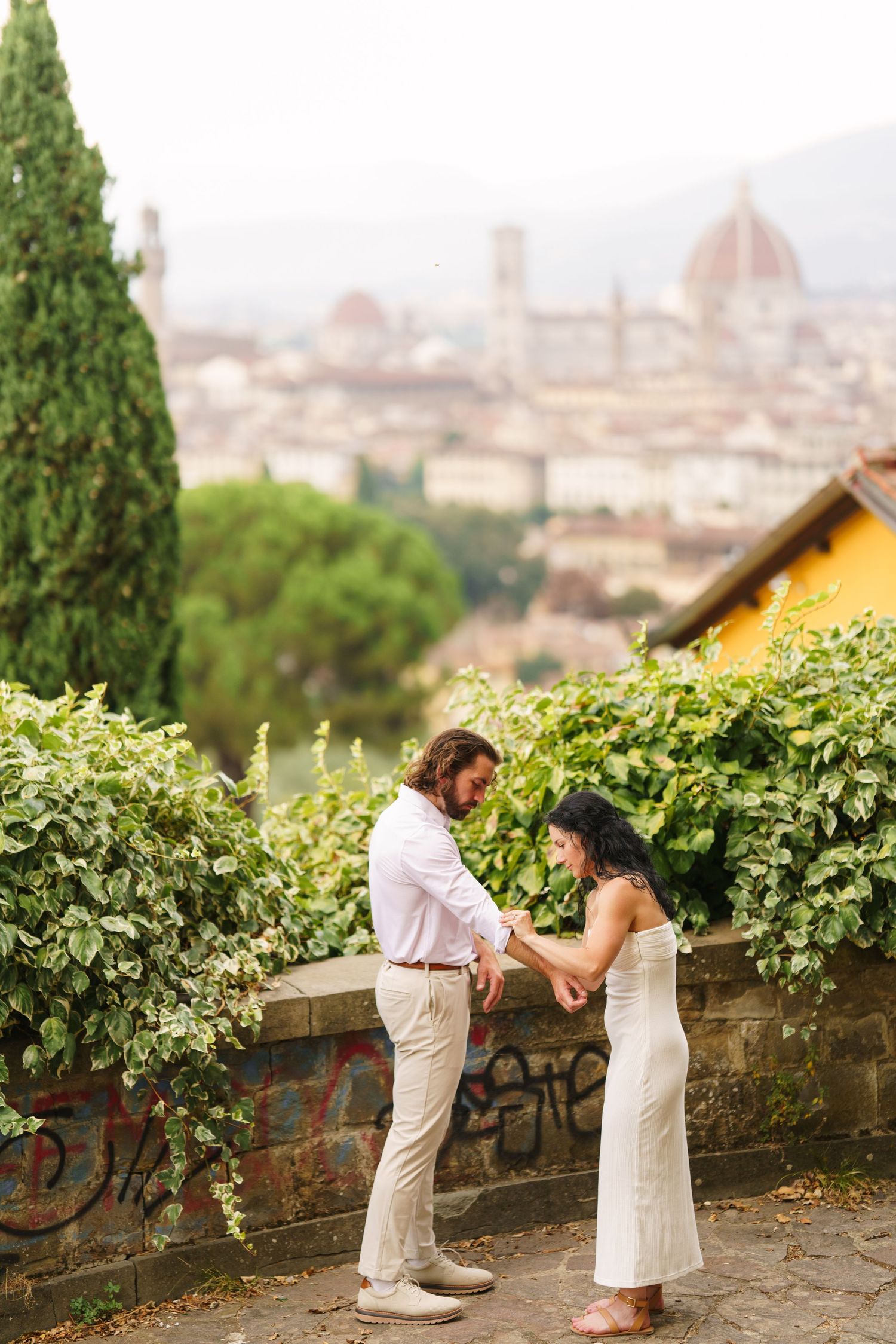 A romantic proposal moment overlooking the scenic Florence skyline with the Duomo cathedral visible in the distance.