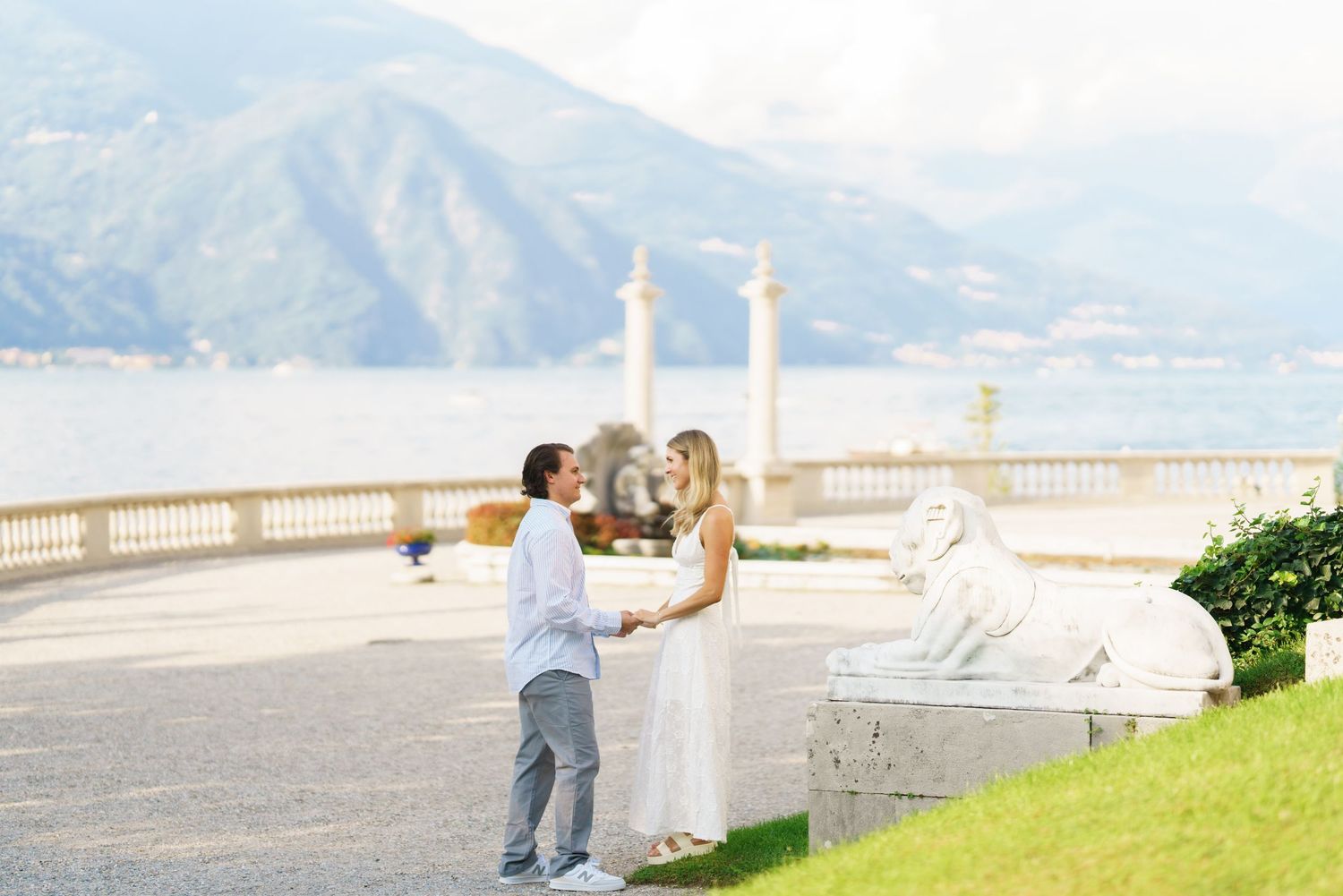 A scenic outdoor wedding photoshoot on a balcony overlooking mountains and ocean in Hawaii.