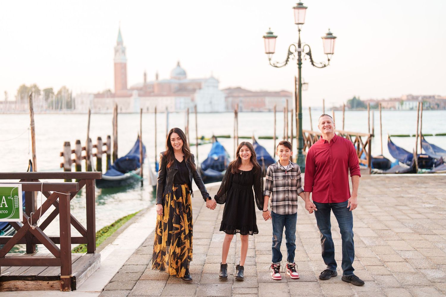 Scenic waterfront view of Venice with gondolas and historic buildings along the canal at sunset.