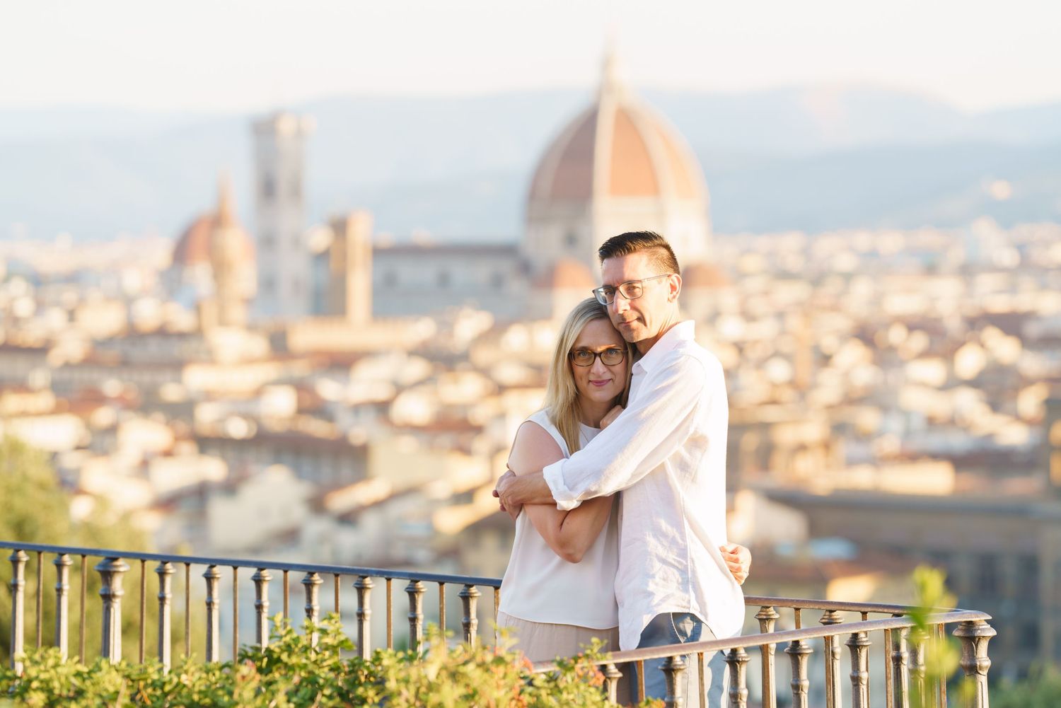 photographer Florence Couple embracing while enjoying panoramic views of Florence, Italy from Piazzale Michelangelo viewpoint.