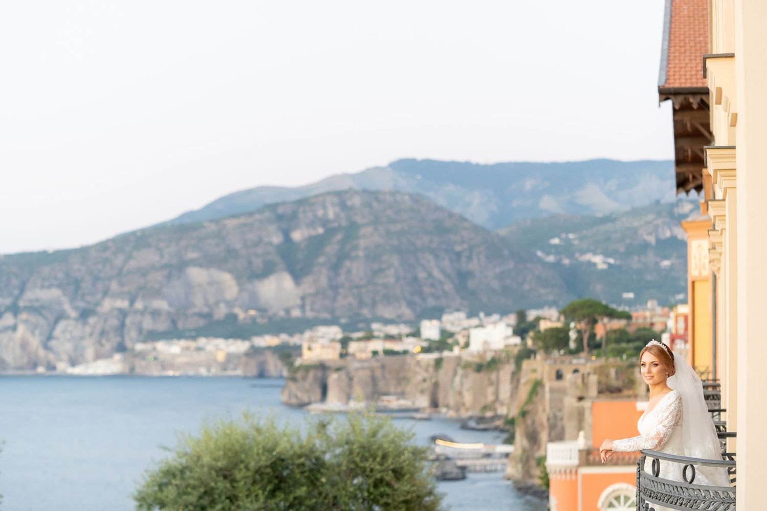 Scenic coastal view of colorful buildings along the Mediterranean Sea with mountains in the background at Sorrento, Italy.
