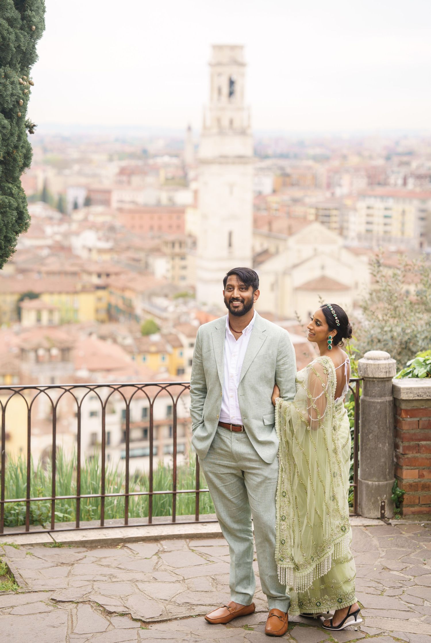 A couple enjoys a romantic moment overlooking the historic cityscape of Perugia, Italy from a scenic viewpoint.