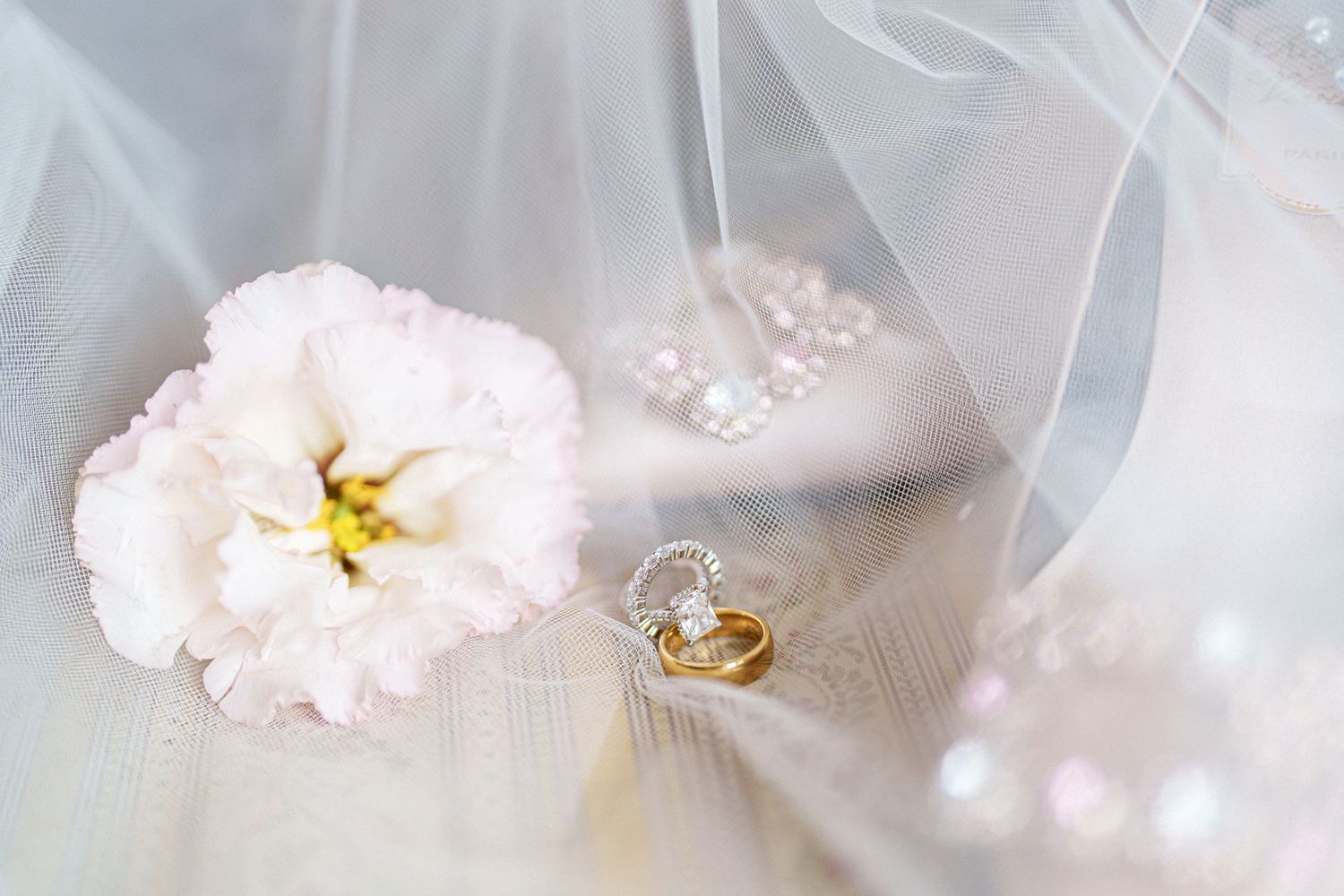 Delicate white flowers and pearls arranged with wedding veil details.