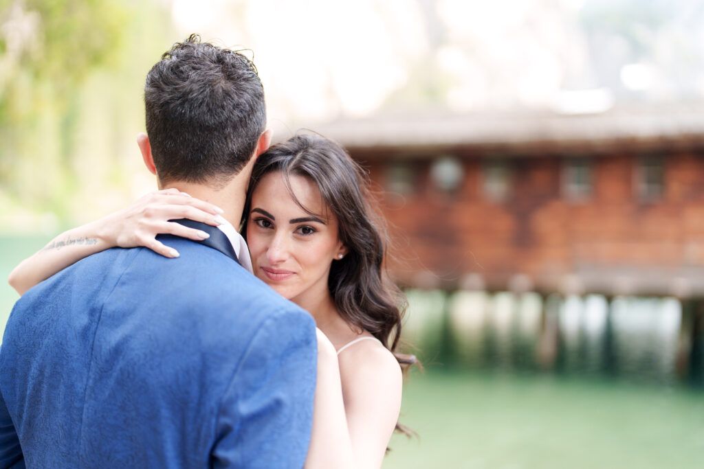 Intimate wedding moment captured against mountain lake backdrop.