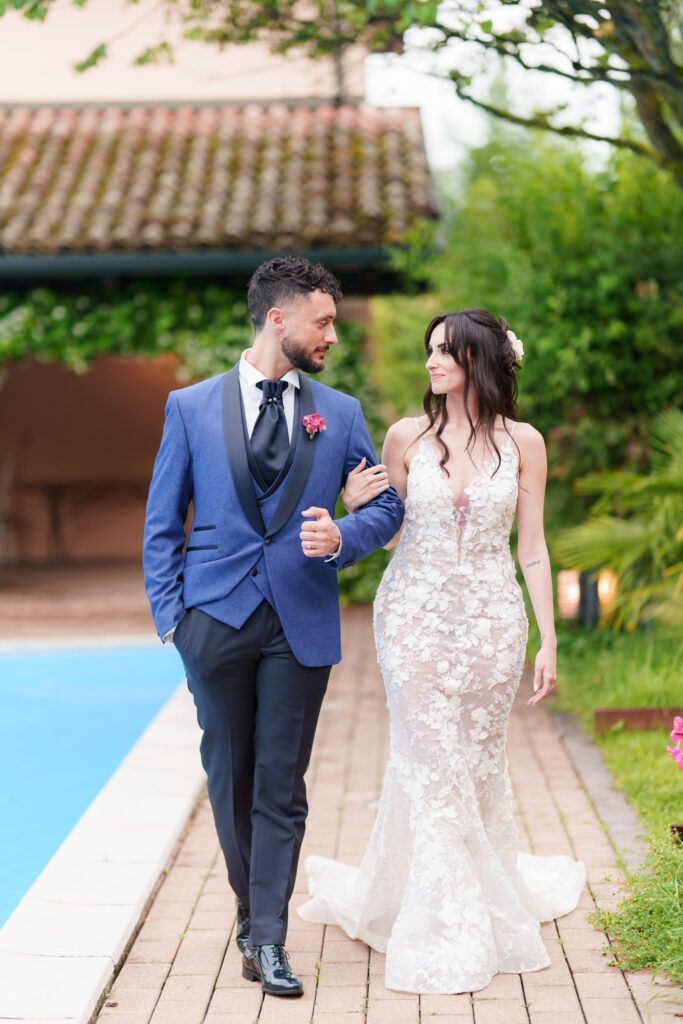 Elegant couple sharing a romantic moment on a wooden deck surrounded by garden scenery.