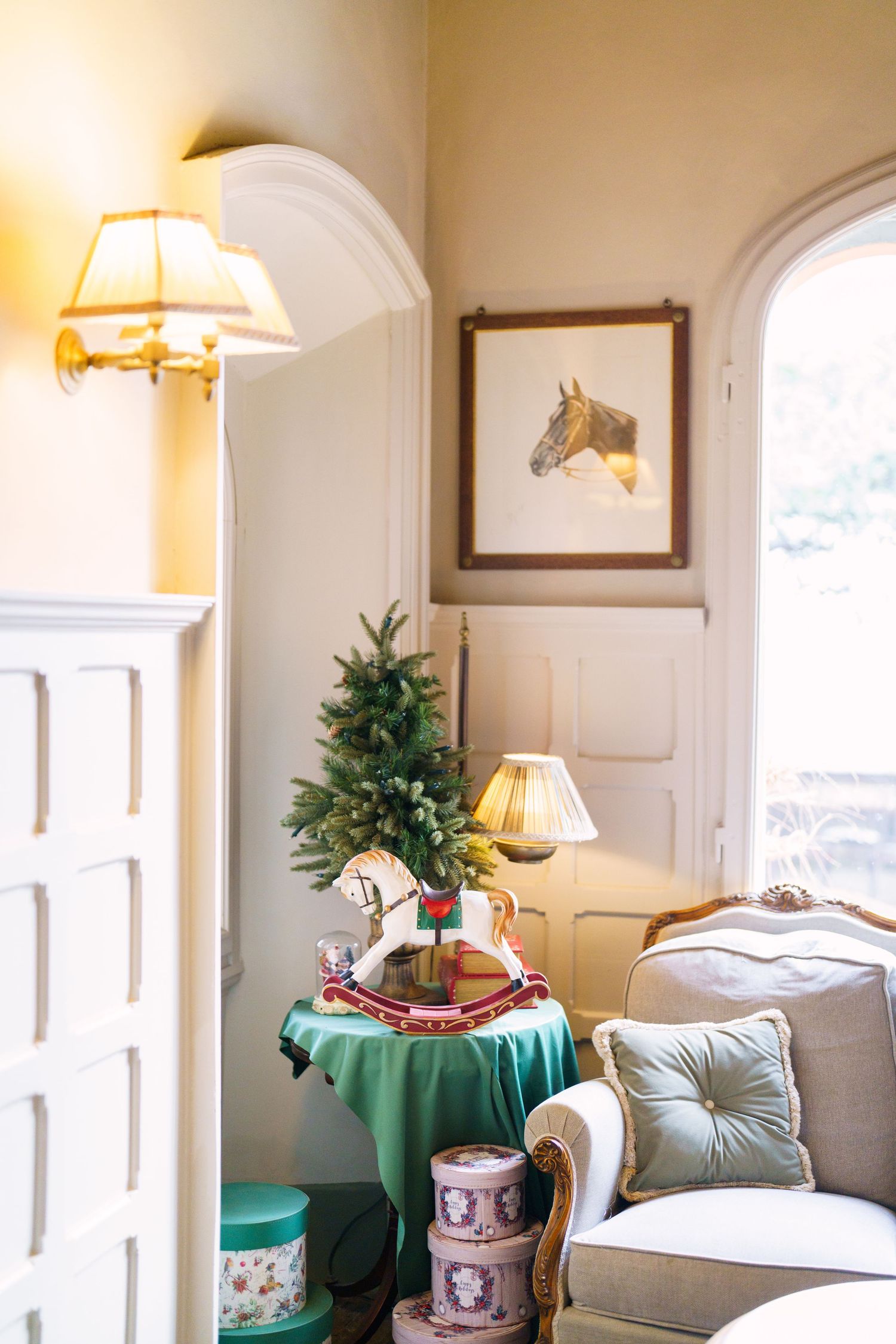 Elegant sitting room with arched windows, vintage furniture, and soft lighting.