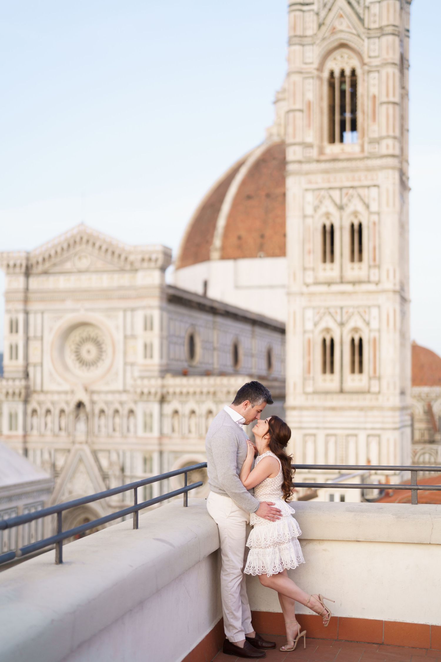 A romantic couple shares intimate moments on a terrace overlooking the historic Florence Cathedral in Italy.