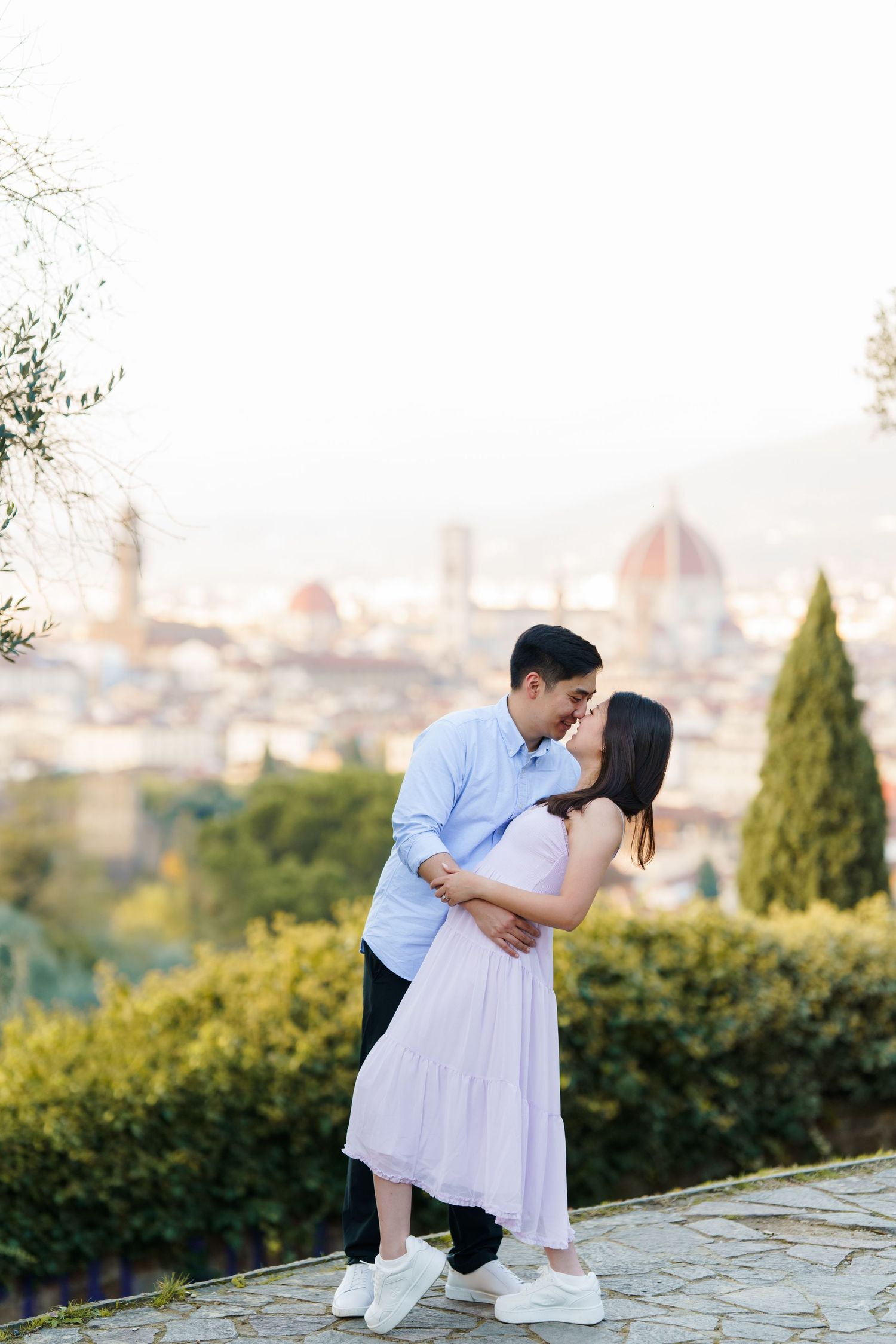 A romantic couple embraces while overlooking Florence's iconic skyline with the Duomo visible in the distance.