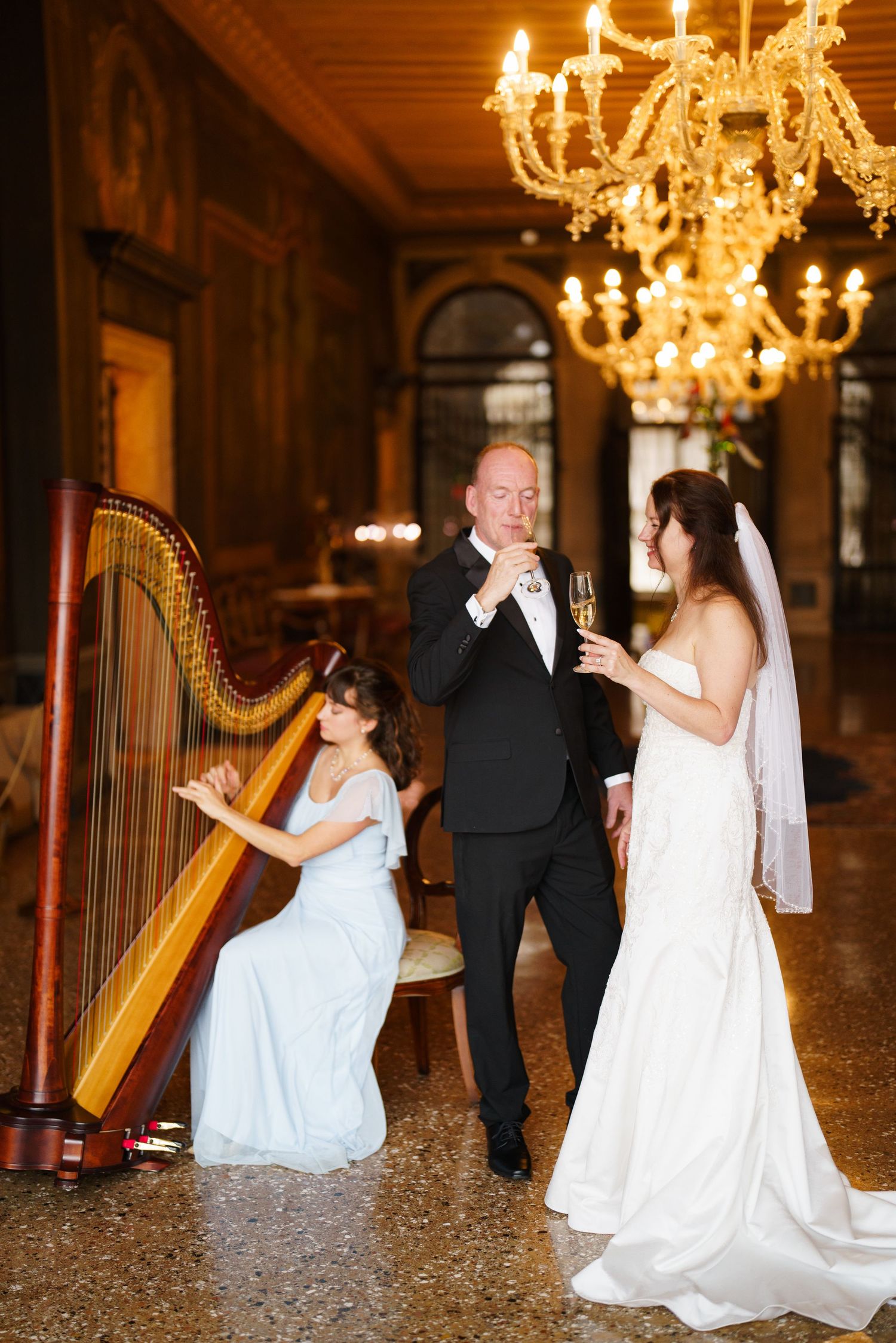 A sequence of five wedding photos showing a bride with a harp in an elegant ballroom with chandeliers and marble floors.