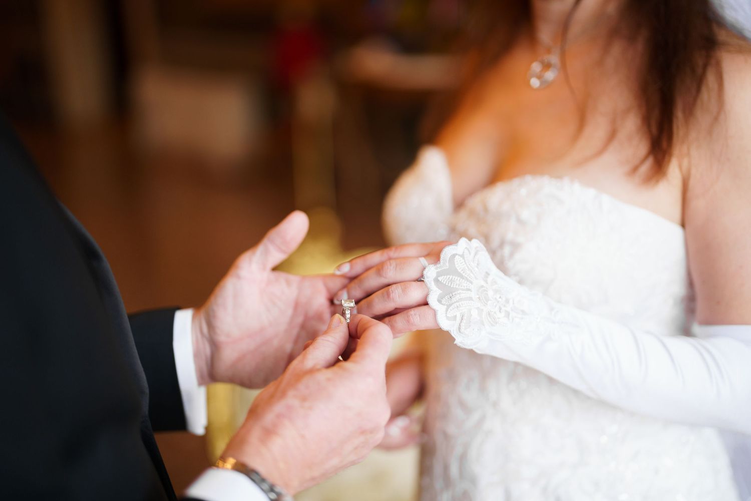 A series of hands and arms in formal attire gesturing and interacting during what appears to be a wedding celebration.