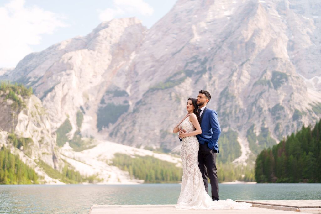 Romantic lakeside wedding photos with dramatic mountain backdrop in the Dolomites.