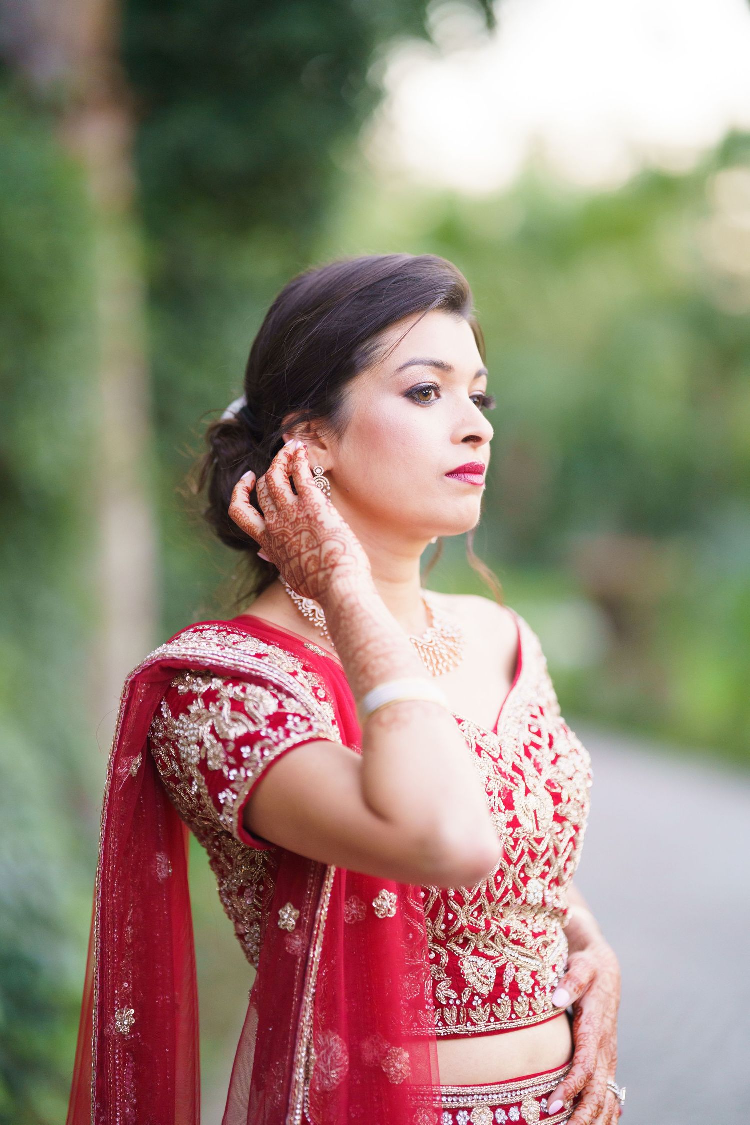 Traditional Indian bridal attire featuring intricate embroidery and beadwork on a red lehenga.