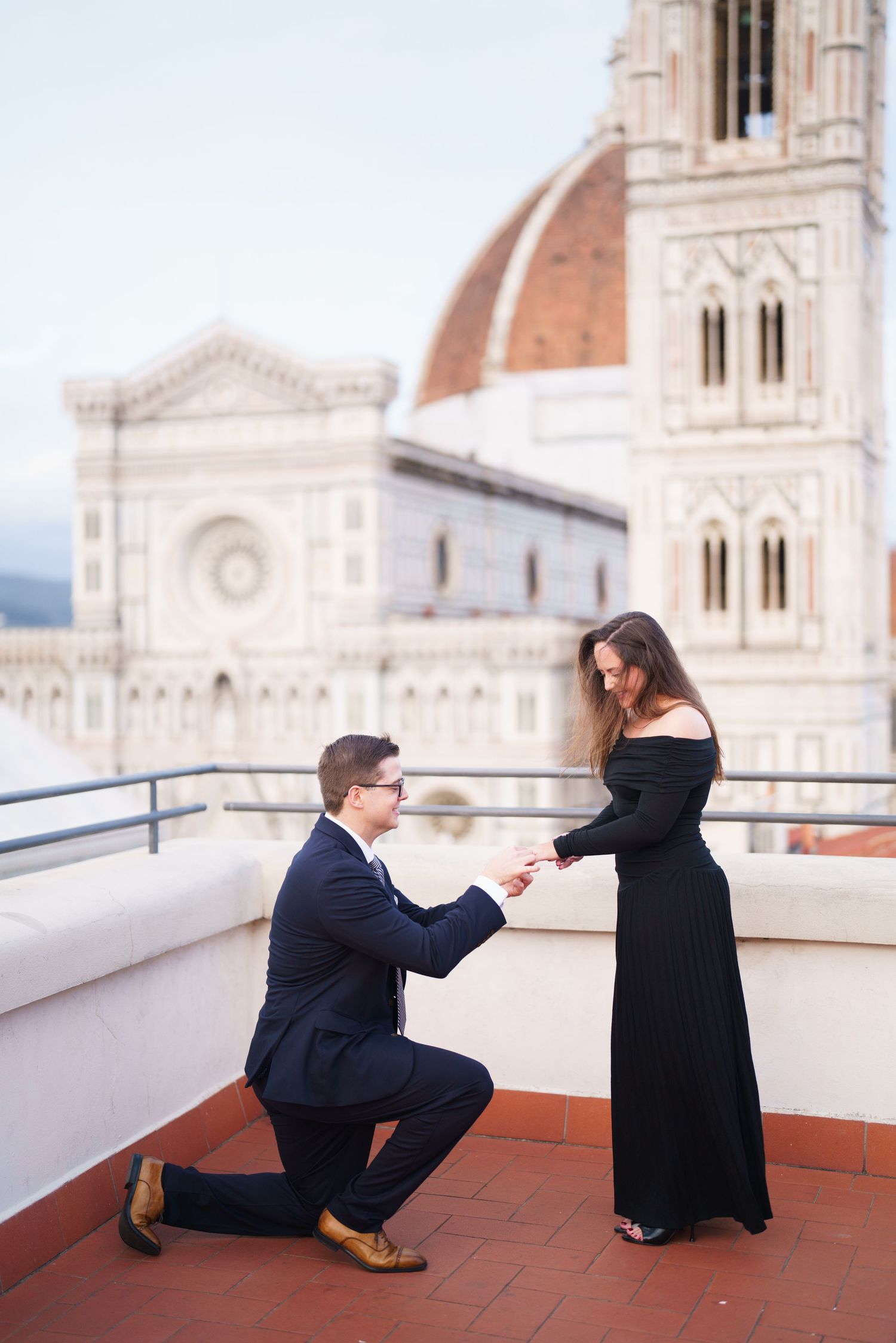A romantic proposal moment on a rooftop terrace overlooking the Florence Cathedral and Brunelleschi's Dome in Italy.