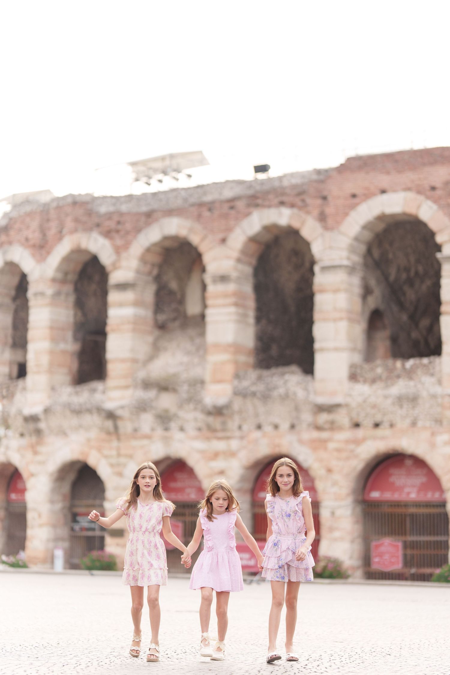 Verona family photographer family walking in front of Verona Arena Italy