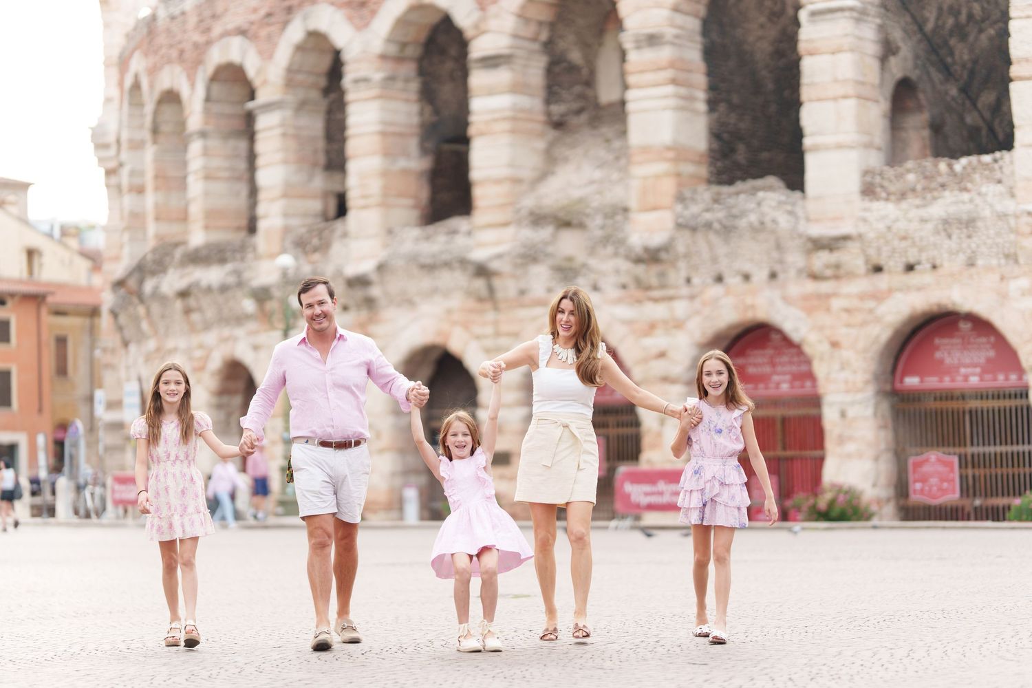 Verona family photographer family walking in front of Verona Arena Italy