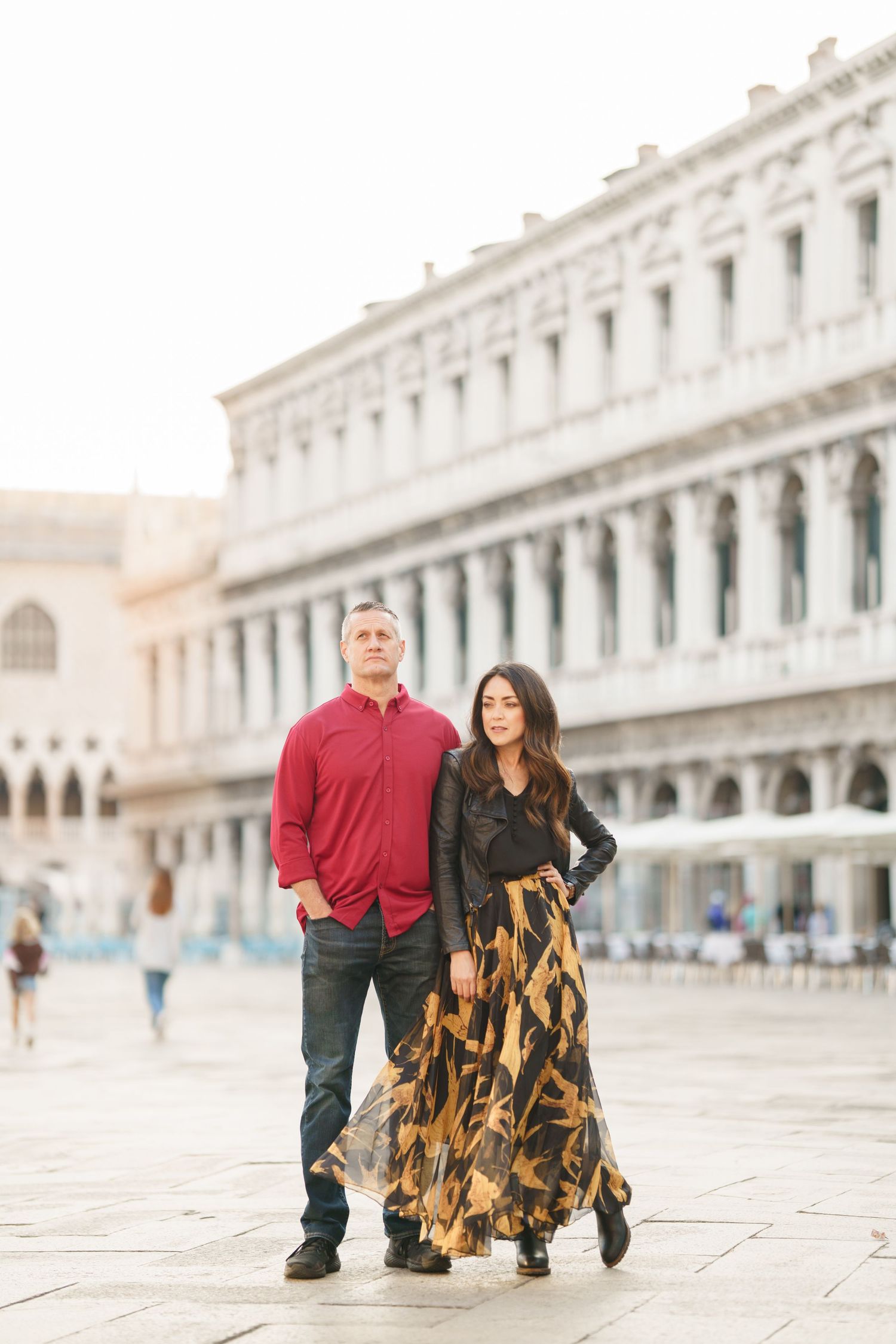 photographer veniceA couple walks together in Venice's iconic St. Mark's Square during a romantic photoshoot.