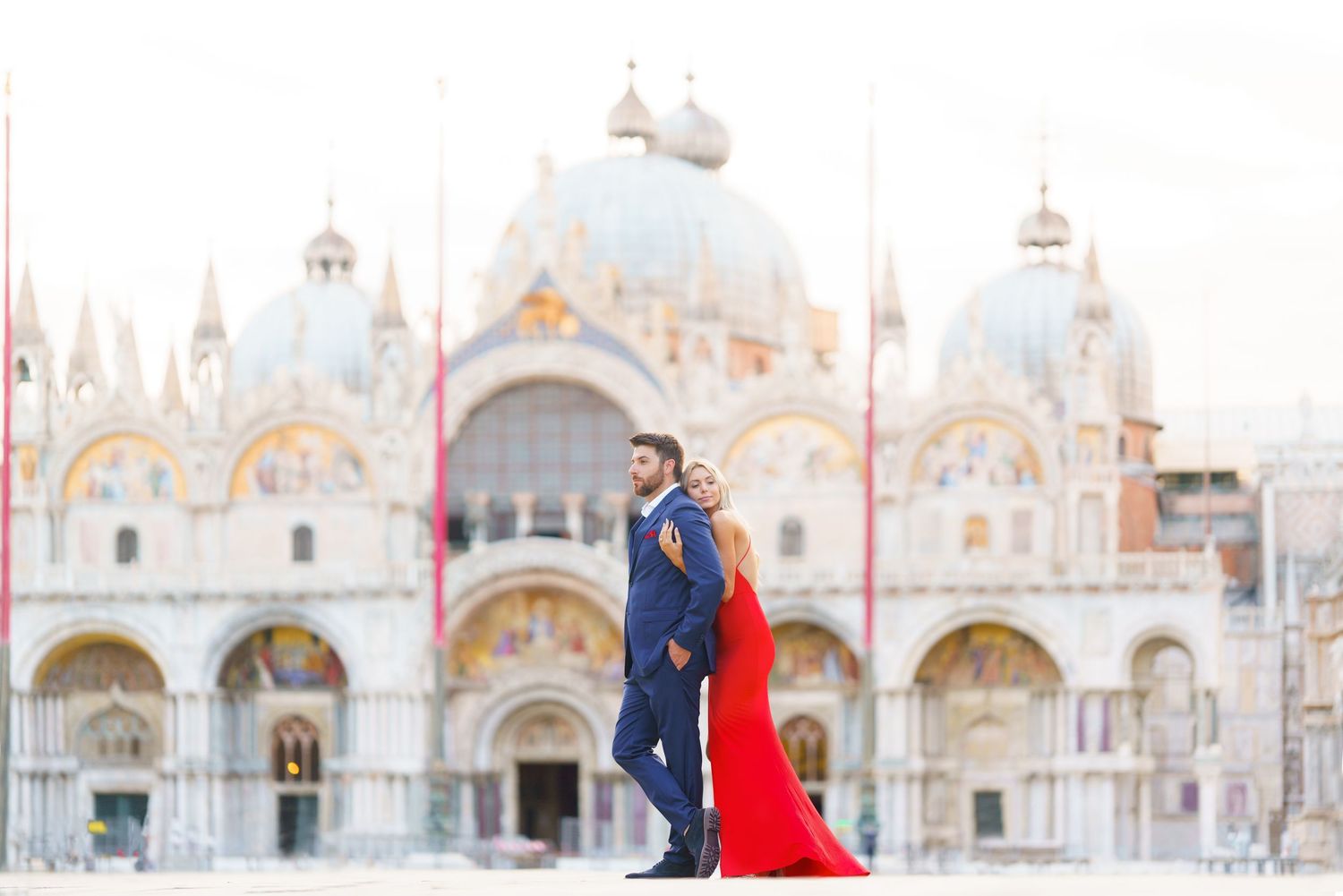 Couple poses in front of St Mark's Basilica in Venice during a romantic photoshoot at sunset.