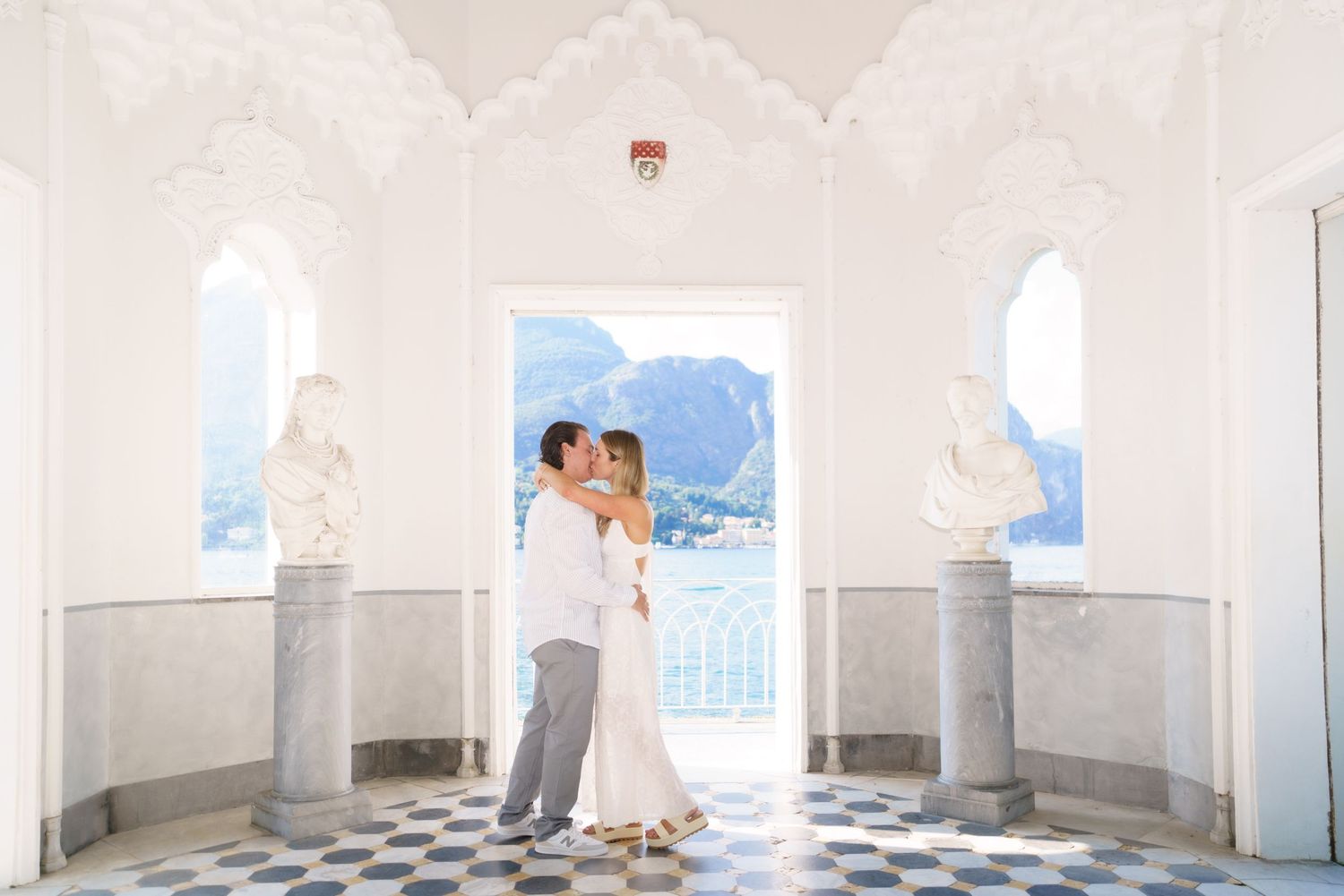 Panoramic view of a white Mediterranean-style colonnade with blue and white checkered floor tiles.